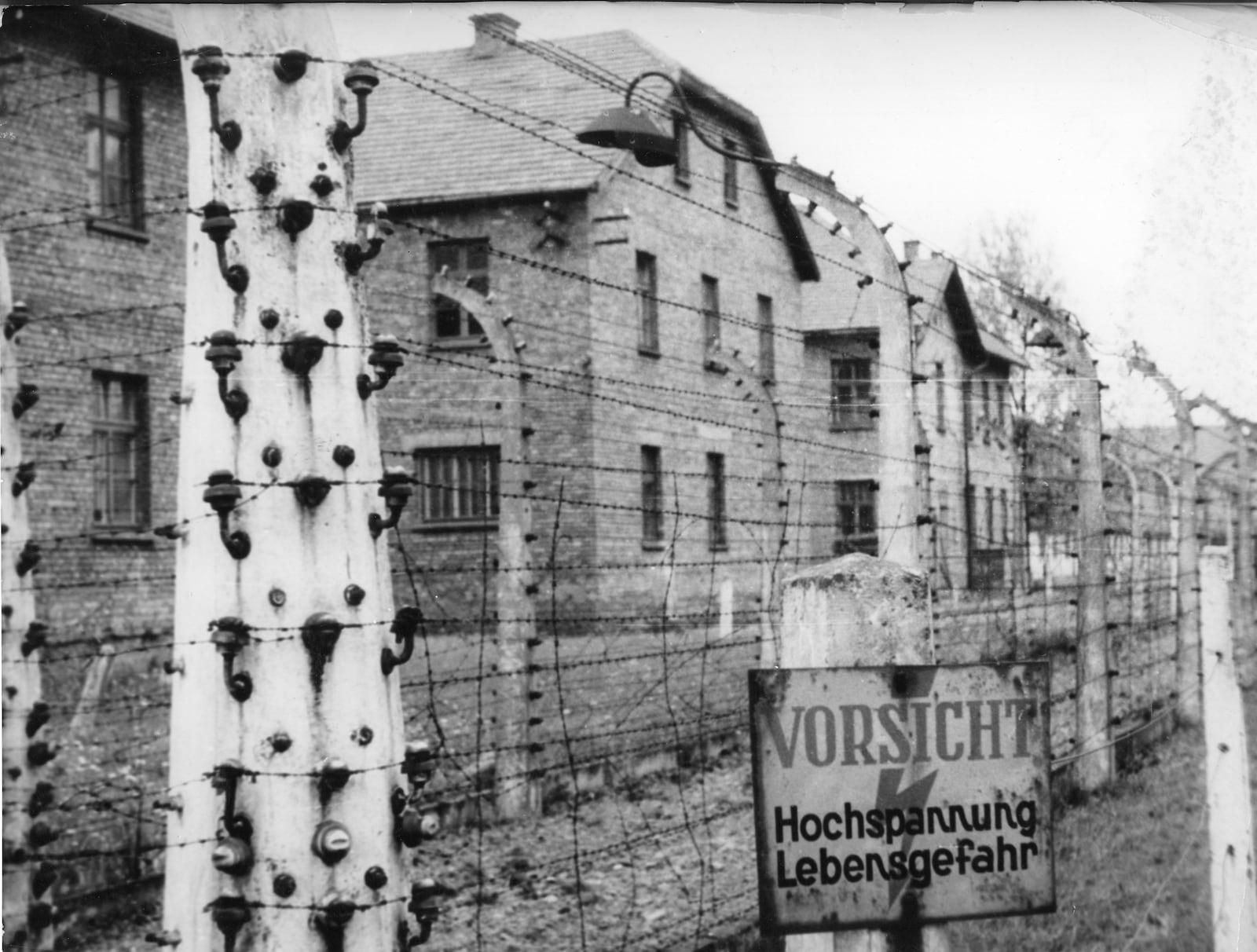 FILE - This June 1958 image shows buildings behind a defunct high voltage electric fence of the Nazi concentration camp Auschwitz I, Poland, which was liberated by the Russians, January 1945. (AP photo, File)