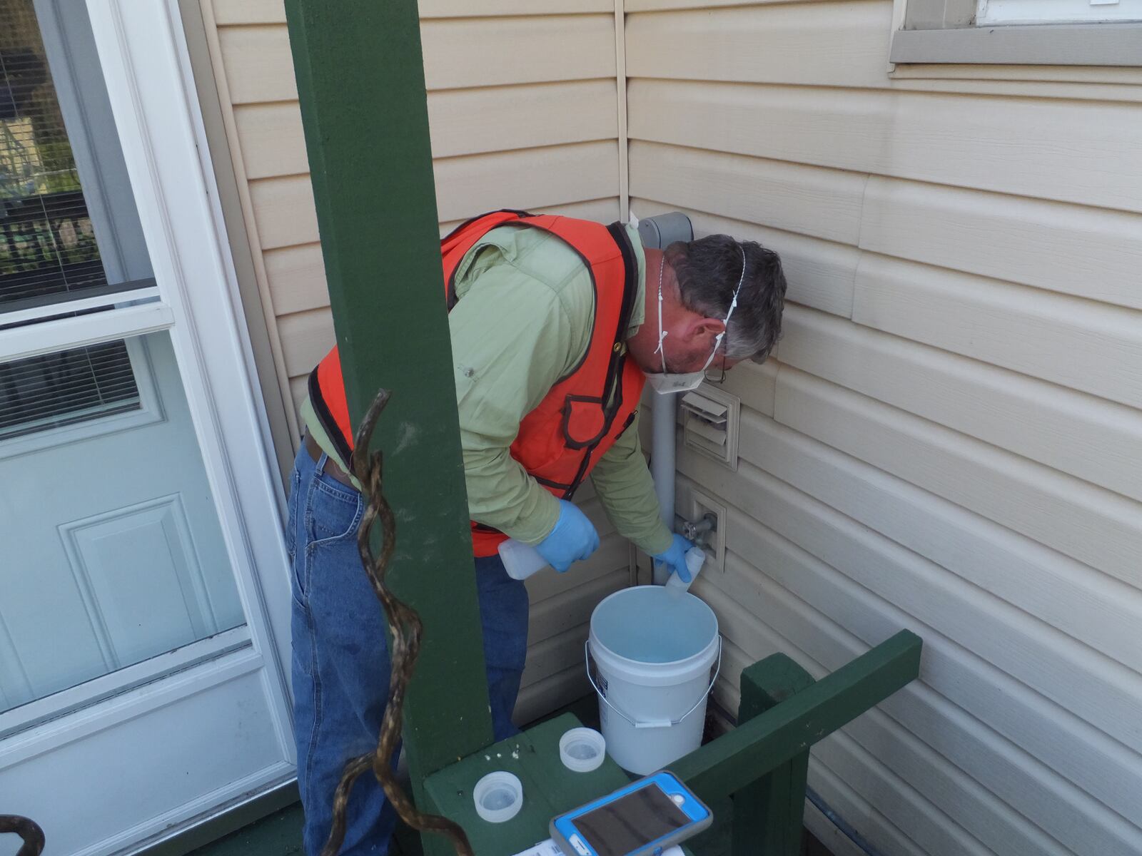 A Wright Patterson Force Base contractor collect drinking water samples from a home in Fairborn in May. The base sampled 22 wells in nearby neighborhoods for a group of contaminants known as PFAS. Contributed