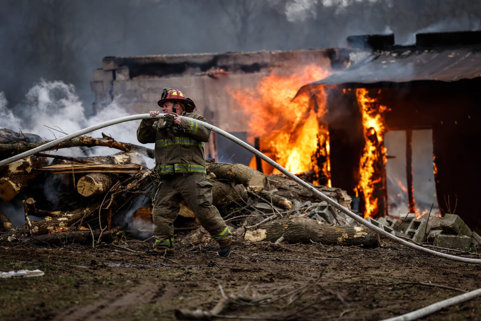 An outdoor fire apparently was spread by wind Thursday, March 31, 2022, to a wooden structure behind a house in the 3700 block of Old Troy Pike in Riverside. JIM NOELKER/STAFF