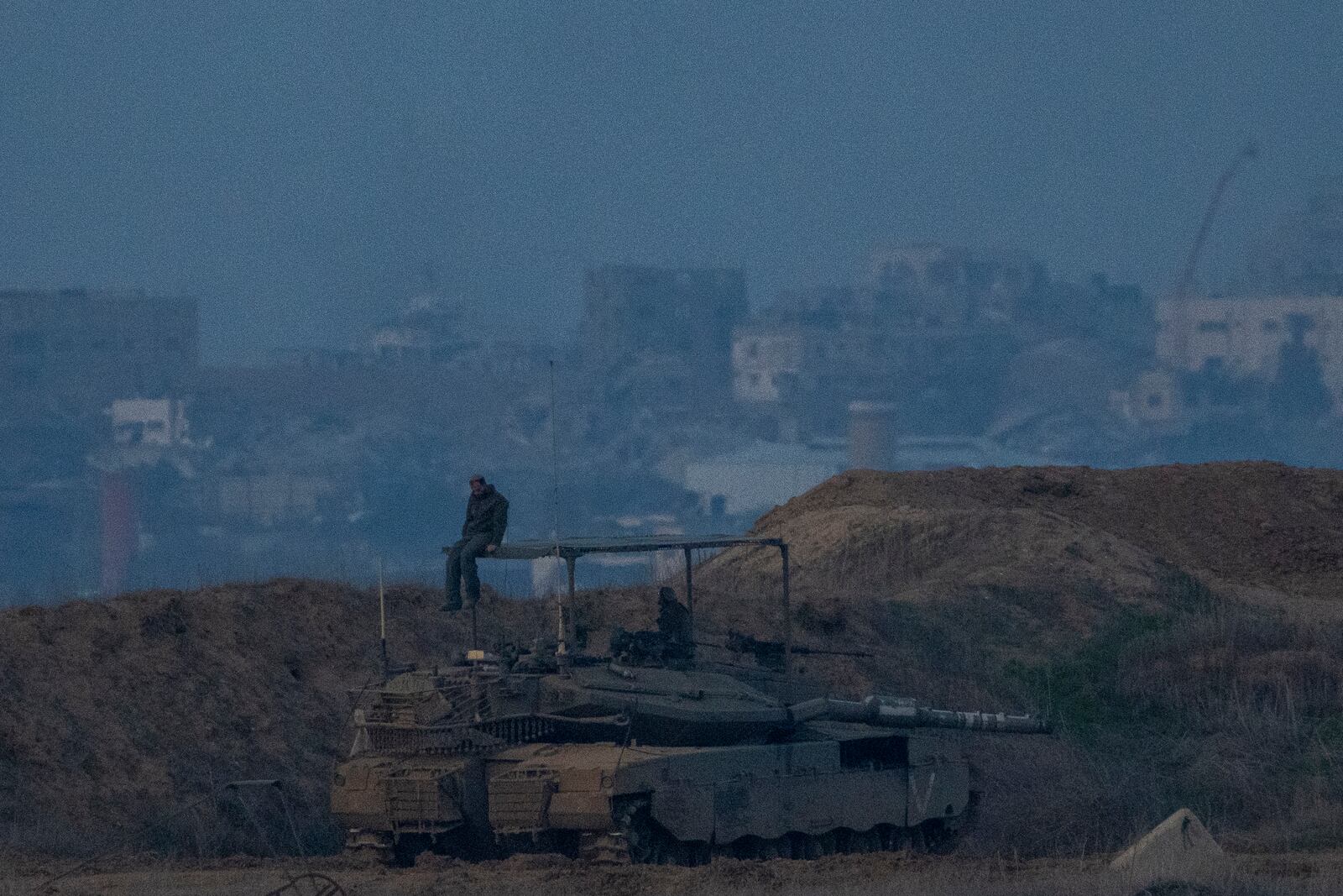 An Israeli soldier sits on a tank at the border with Gaza in southern Israel on Thursday, Jan. 16, 2025. (AP Photo/Ariel Schalit)