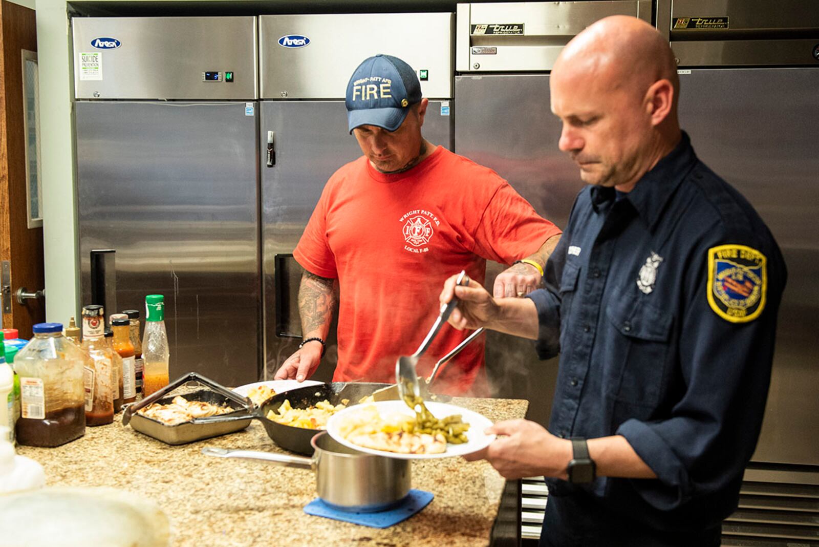 Brian Wilcher (right), 788th Civil Engineer Squadron lead firefighter, and Brian Grubb, a firefighter and paramedic, get their dinner inside Station 1 at Wright-Patterson Air Force Base on June 23. U.S. AIR FORCE PHOTO/WESLEY FARNSWORTH