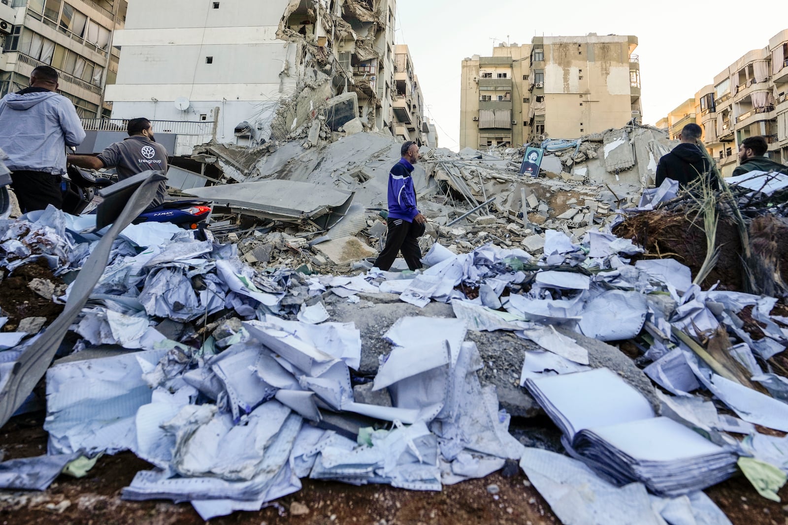 Documents of Hezbollah-run al-Qard al-Hassan are scattered at the site of an Israeli airstrike on Sunday night in Beirut's southern suburb, Lebanon, Monday, Oct. 21, 2024. (AP Photo/Hassan Ammar)