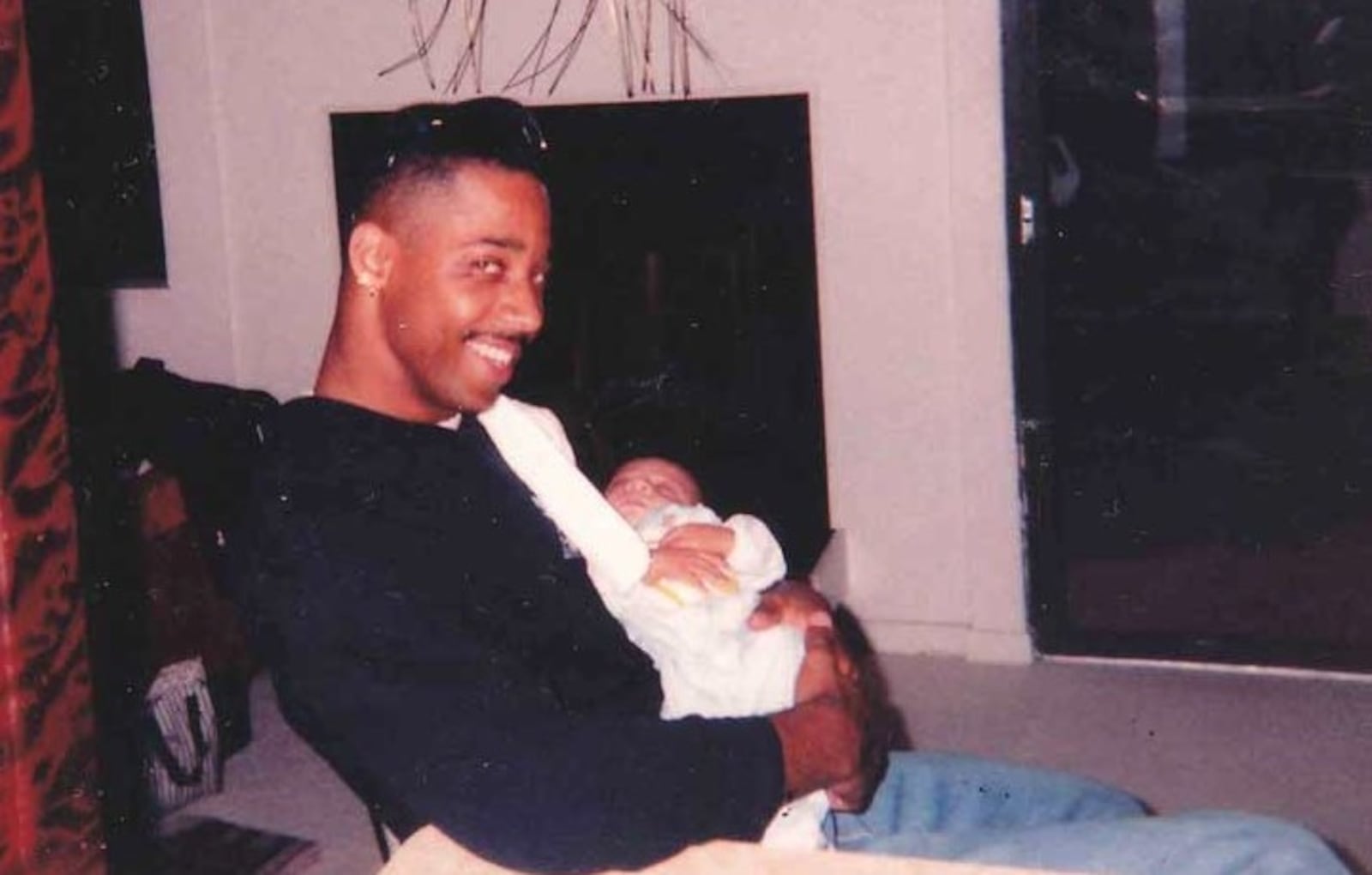 Kevin Brame cradles his newborn son, Dominique, in 1994.