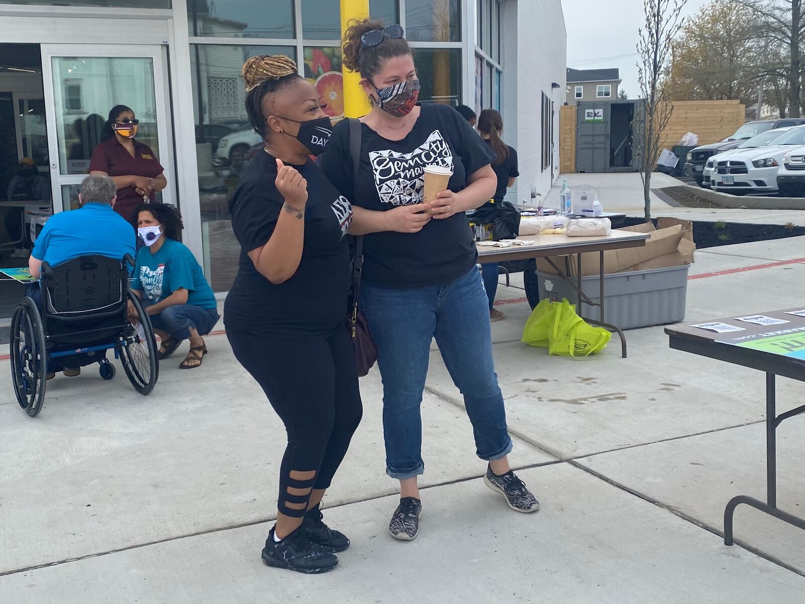 Billi Ewing, left, and Lela Klein, right, dance in front of the Gem City Market in Dayton on Saturday during the cleanup. EILEEN McClory/ STAFF