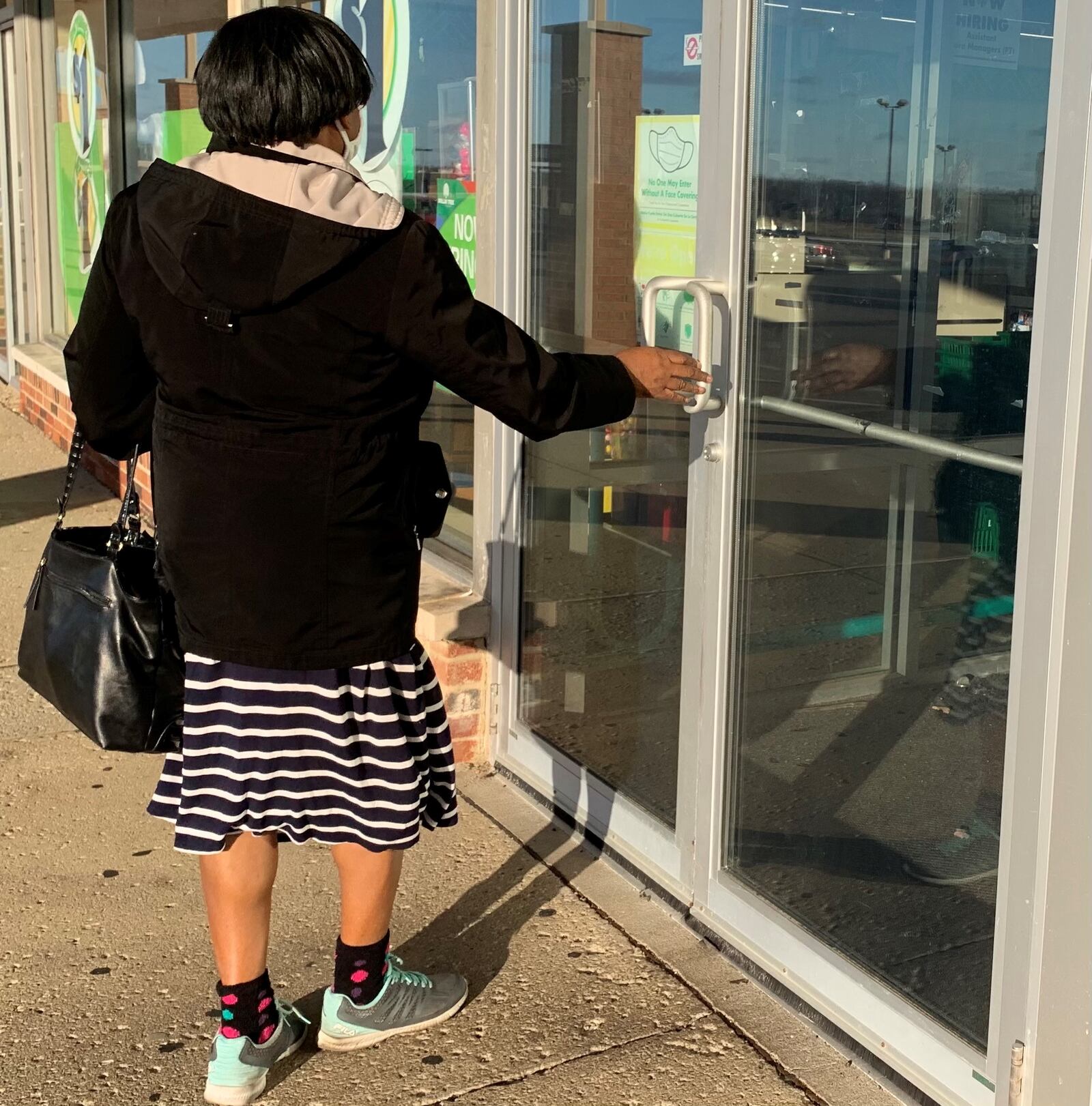 A  shopper enters the Dollar Tree in Trotwood wearing a mask.