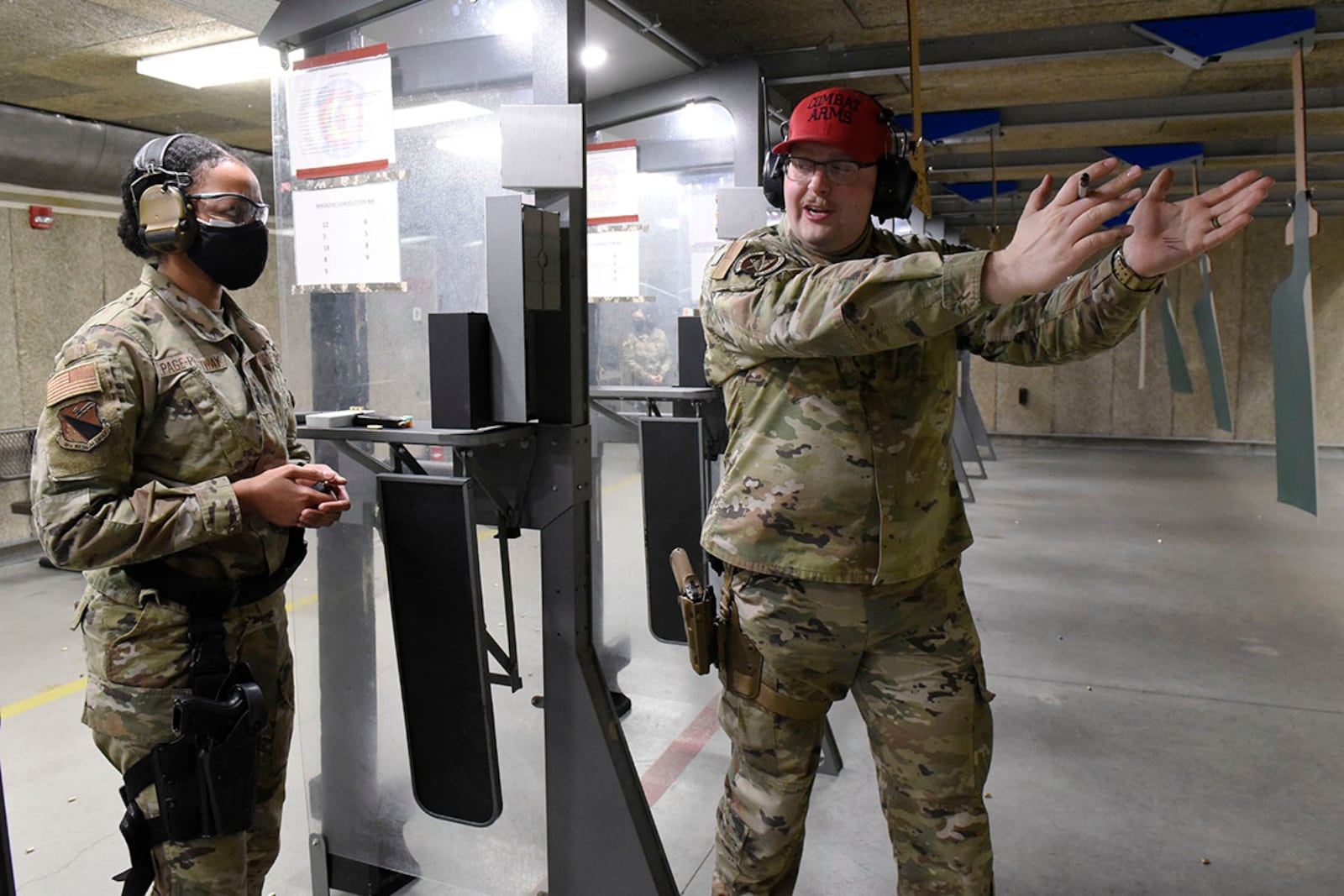 Senior Airman Clayton Nyp (right), an 88th Security Forces Squadron combat-arms instructor, works with 1st Lt. Elisabeth Page-Pettiway, an 88th Medical Group executive officer, as she qualifies with the M9 pistol inside the 88th Security Forces Squadron firing range at Wright-Patterson Air Force Base on Feb. 18. Weapons qualification is part of 88th Air Base Wing readiness standards. U.S. AIR FORCE PHOTO/TY GREENLEES