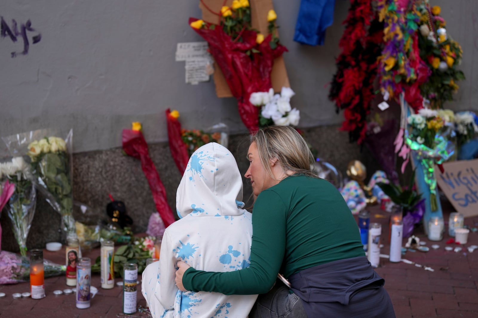 Kelli Galle, right, hugs her son Parker, left, as they visit a memorial to the victims of a deadly truck attack on Bourbon Street in the French Quarter, Friday, Jan. 3, 2025, in New Orleans. (AP Photo/George Walker IV)