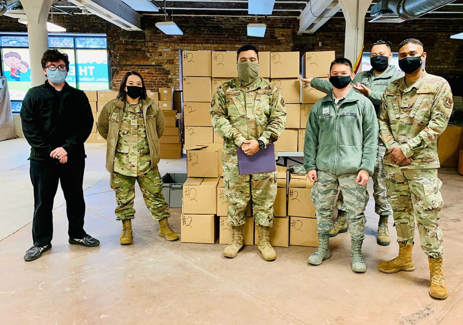 From left: Diego Quevedo, Airman 1st Class Miranda Hutton, Senior Airman Kwame Robertson, Airman 1st Class Jasper Kaamino, Senior Airman Ariel Guzman and Staff Sgt. Randolph Koram put together more than 400 “Love Them Out Loud” kits during the Dec. 18 volunteer event benefiting the Dayton Metro Library and early childhood literacy. CONTRIBUTED PHOTO