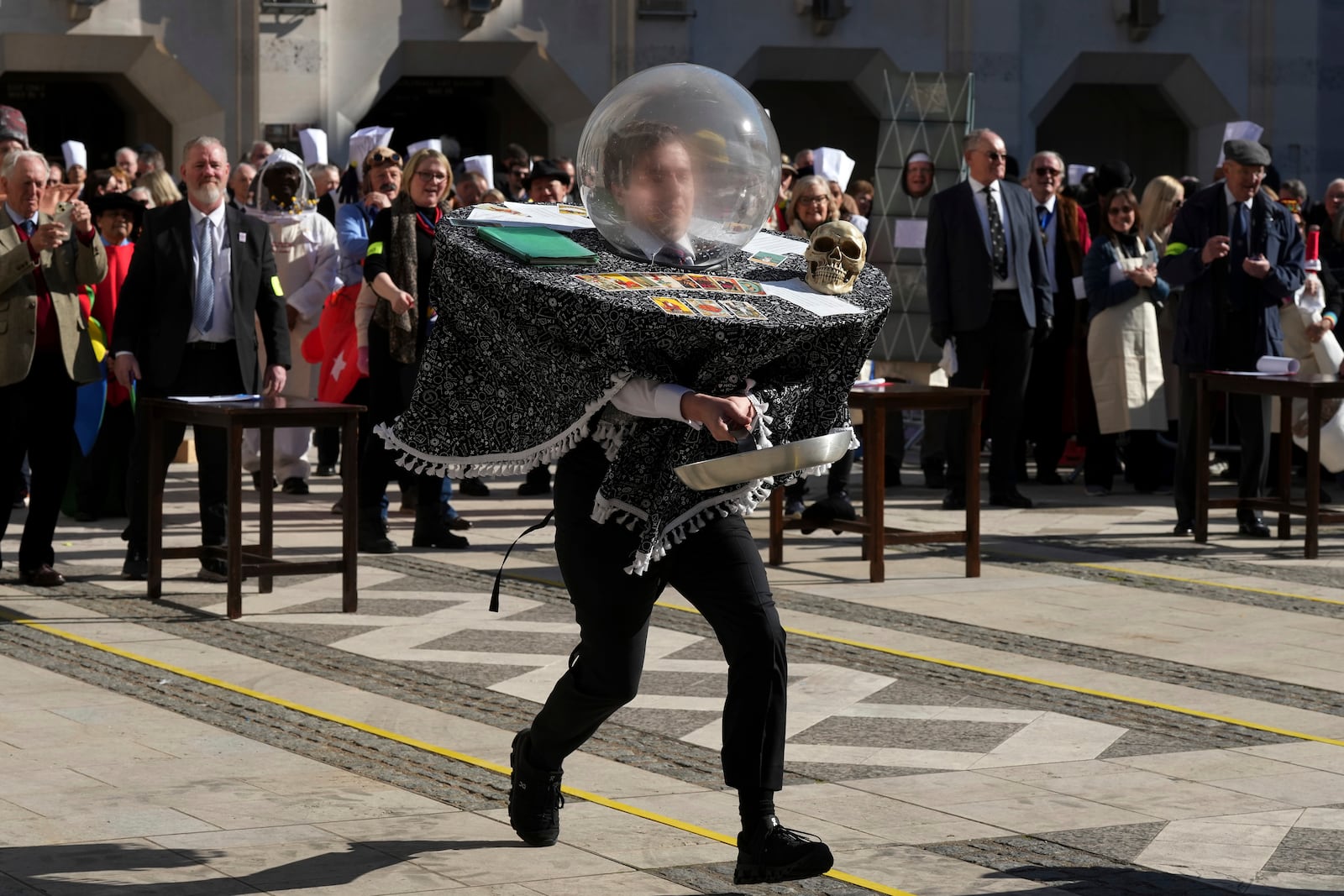 A competitor in a costume runs during a traditional pancake race by livery companies at the Guildhall in London, Tuesday, March 4, 2025.(AP Photo/Frank Augstein)