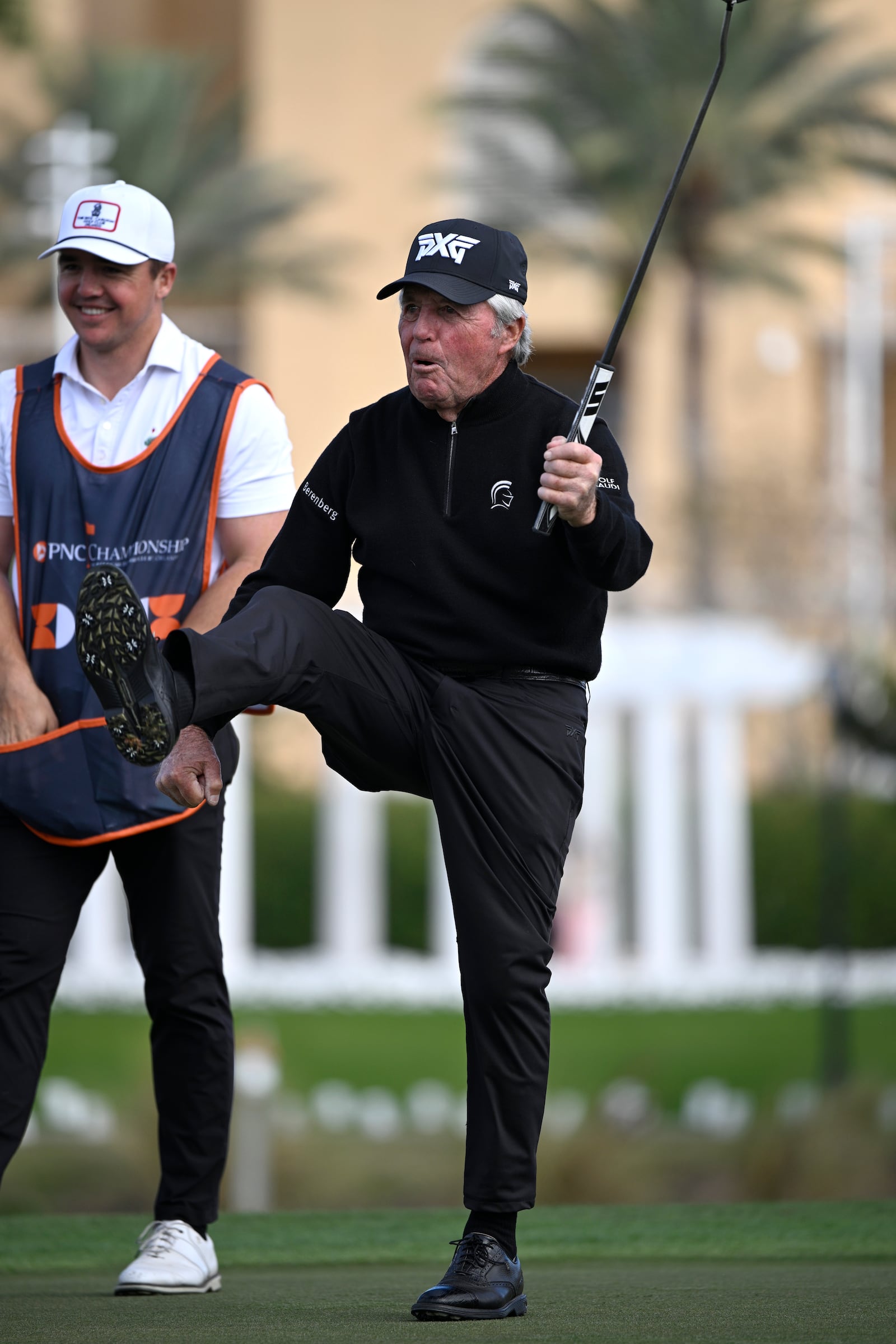 Gary Player, right, celebrates after making a putt on the 18th green as his son Wayne Player looks on during the final round of the PNC Championship golf tournament, Sunday, Dec. 22, 2024, in Orlando, Fla. (AP Photo/Phelan M. Ebenhack)