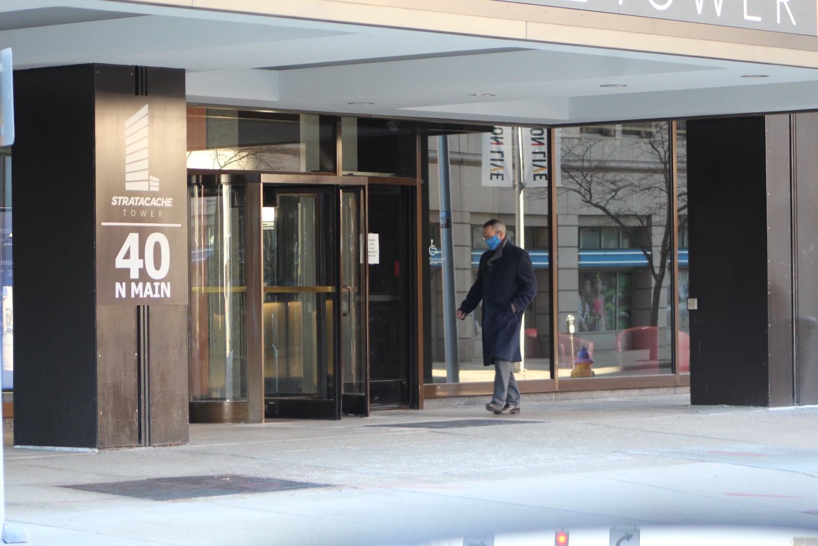 A man walks in to Stratacache Tower in downtown Dayton. Stratacache, a digital signage company, last year received a Paycheck Protection Program loan. CORNELIUS FROLIK / STAFF