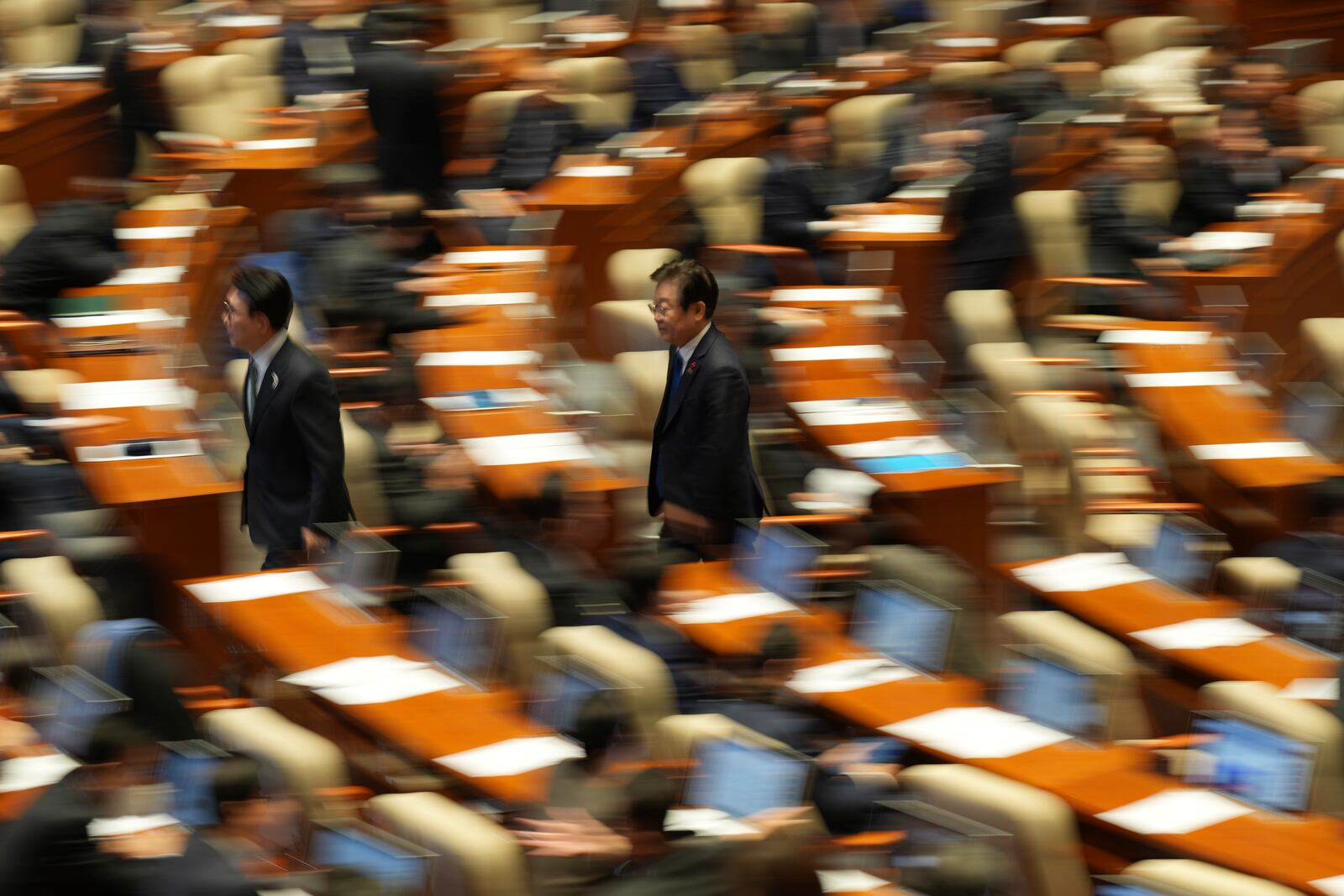 South Korea's main opposition Democratic Party leader Lee Jae-myung, center, walks back to his seat after he voted on an impeachment bills for the national police chief Cho Ji Ho and justice minister Park Sung Jae during a plenary session held relating to the martial law declaration, at the National Assembly in Seoul, South Korea, Thursday, Dec. 12, 2024. (AP Photo/Lee Jin-man)