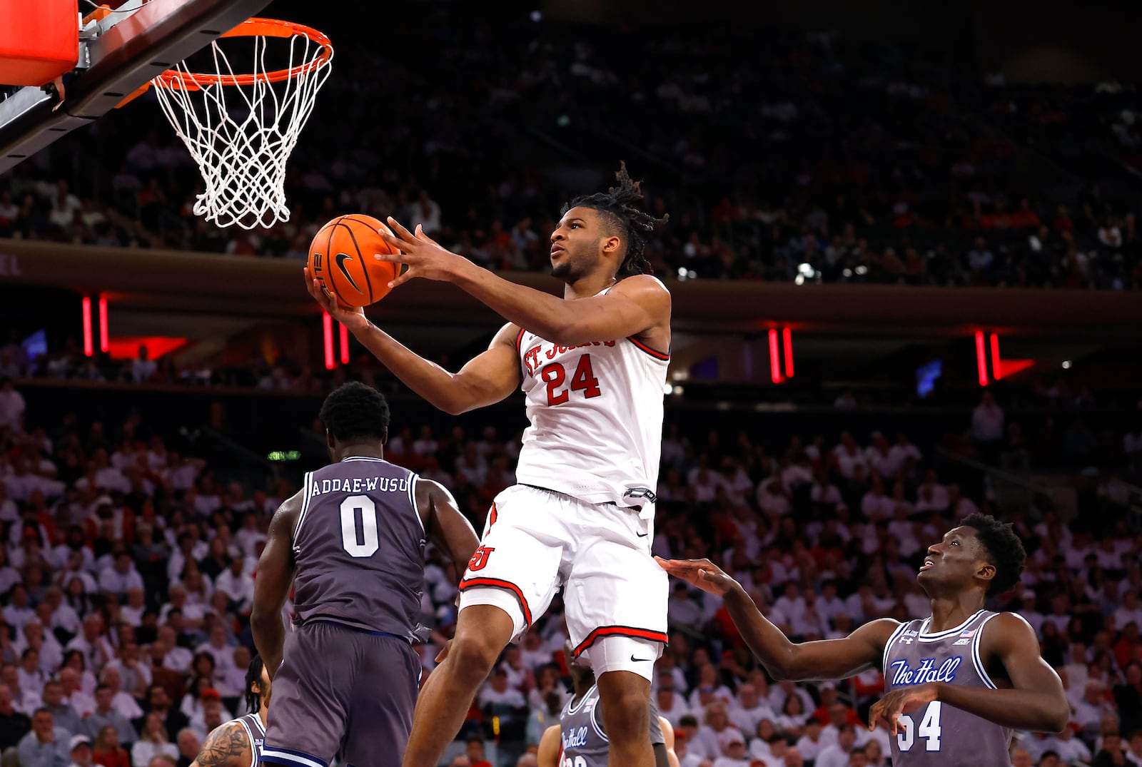 St. John's forward Zuby Ejiofor (24) drives to the basket against Seton Hall guard Dylan Addae-Wusu (0) and center Godswill Erheriene (54) during the second half of an NCAA college basketball game, Saturday, March 1, 2025, in New York. (AP Photo/Noah K. Murray)