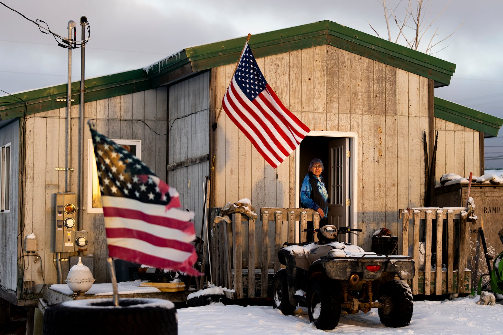 Alice Aishanna poses for a portrait outside her home displaying several American flags in Kaktovik, Alaska, Tuesday, Oct. 15, 2024. (AP Photo/Lindsey Wasson)