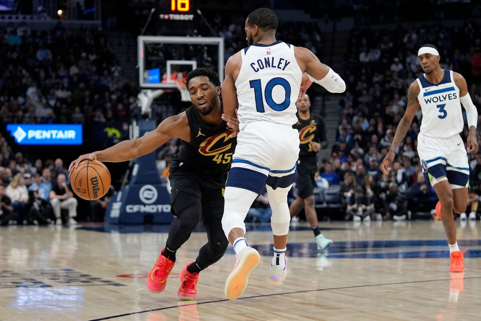 Cleveland Cavaliers guard Donovan Mitchell (45) works toward the basket as Minnesota Timberwolves guard Mike Conley (10) defends during the first half of an NBA basketball game, Saturday, Jan. 18, 2025, in Minneapolis. (AP Photo/Abbie Parr)