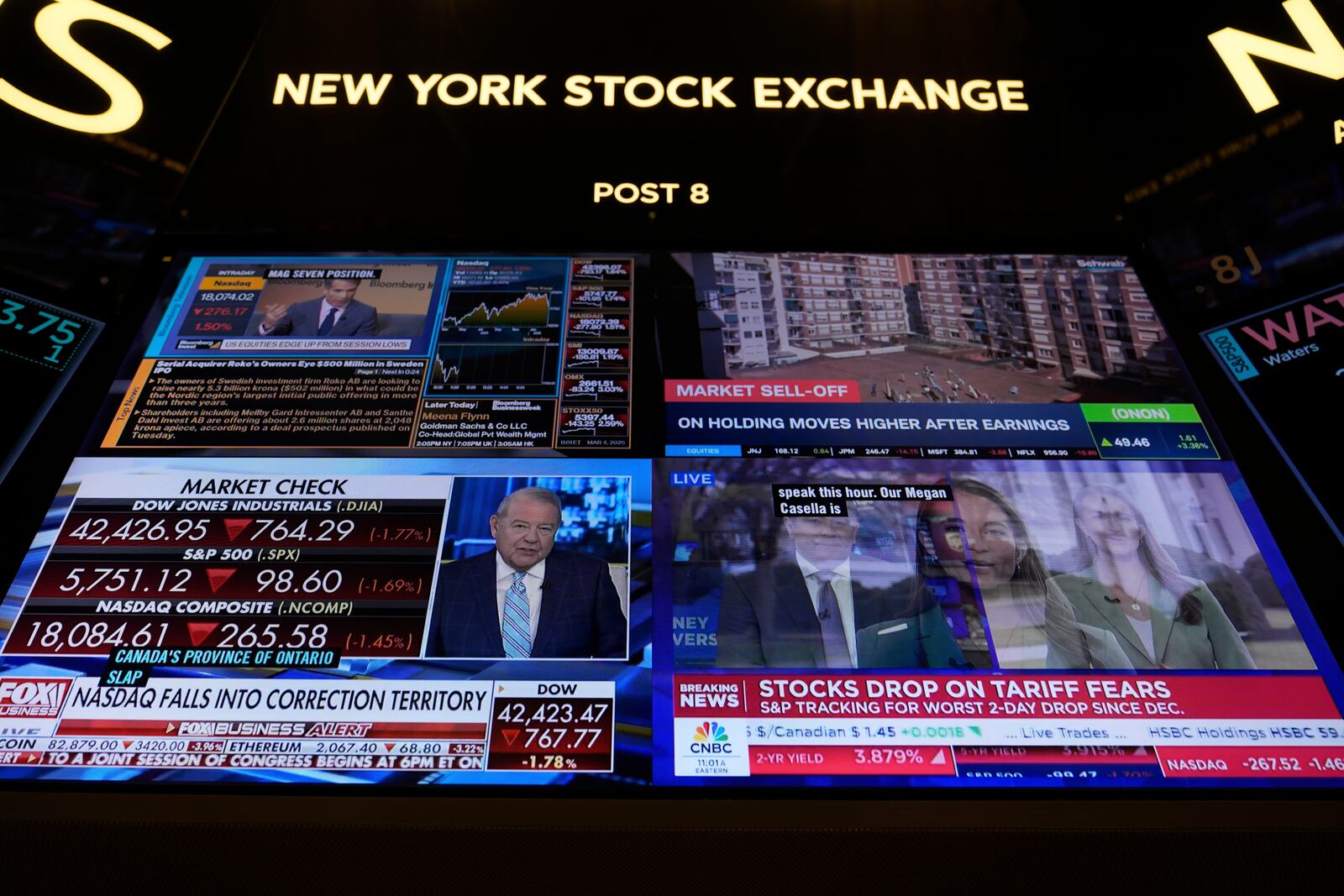 Financial news is displayed as people work on the floor at the New York Stock Exchange in New York, Tuesday, March 4, 2025. (AP Photo/Seth Wenig)