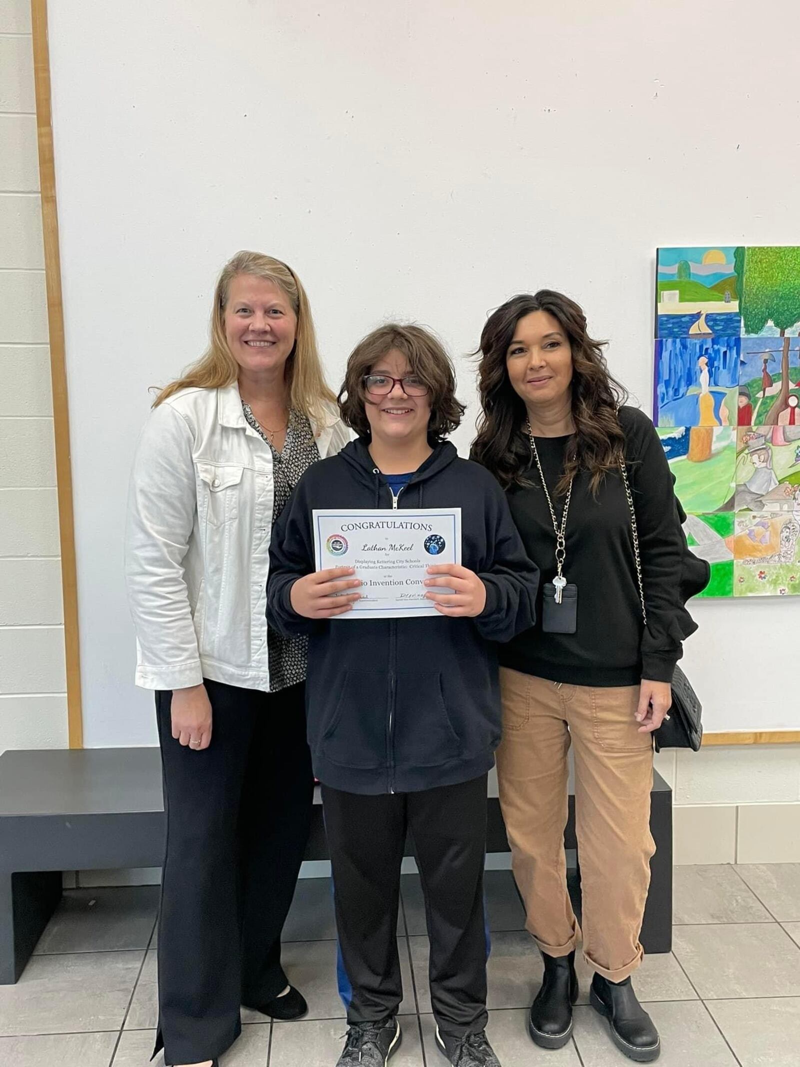 Lynn Cannarozzi (left) and Karen Kronaur recognize Lathan at the Kettering School Board Meeting for placing fourth in the Ohio Invention Convention. CONTRIBUTED