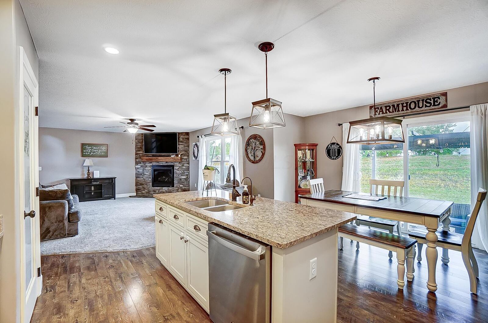 The open concept kitchen and living room has access to the back yard via sliding glass doors. There is a corner stone gas fireplace in the living room.