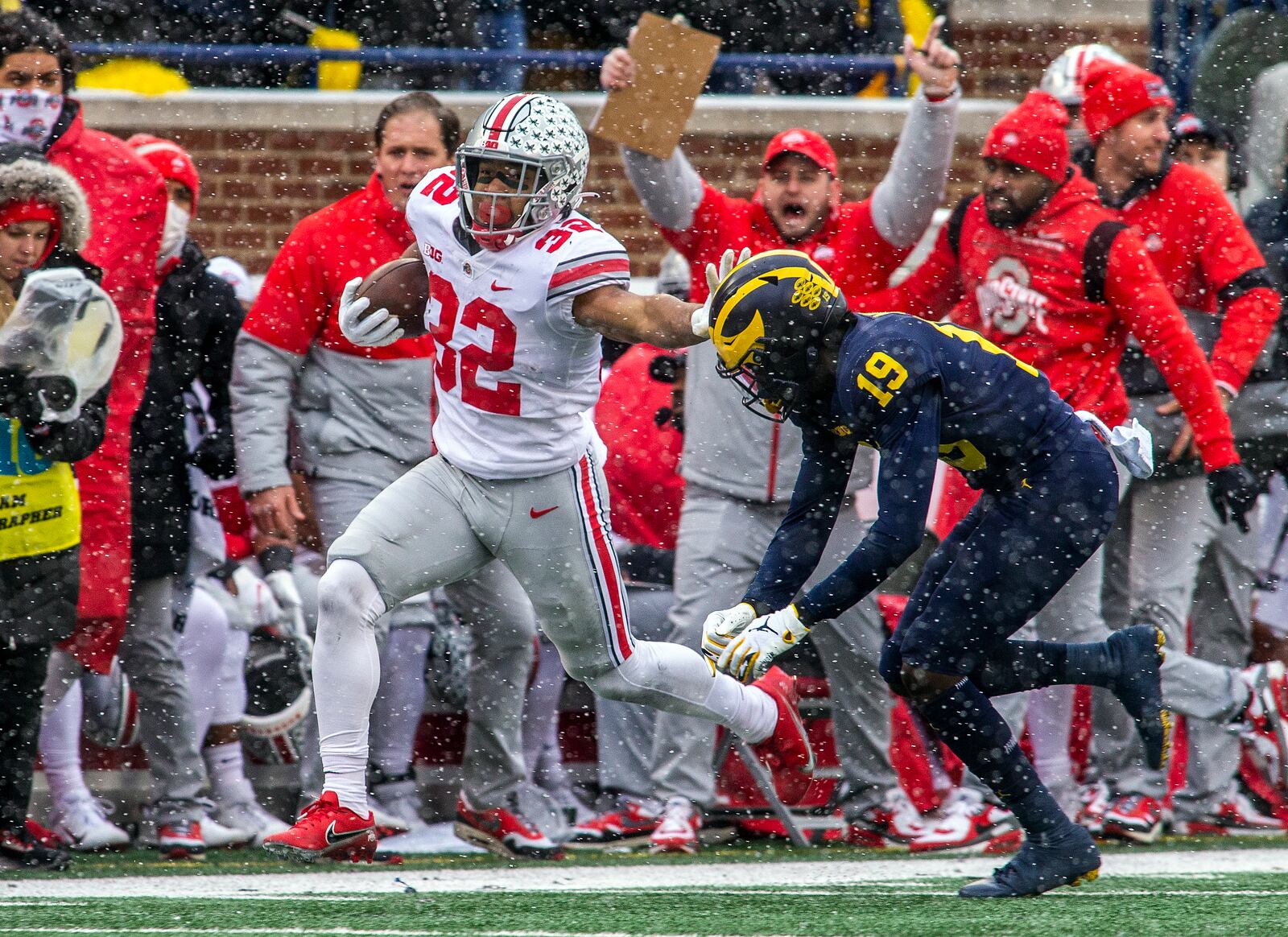 Ohio State running back TreVeyon Henderson (32) tries to fend off Michigan defensive back Rod Moore (19) in the first quarter of an NCAA college football game in Ann Arbor, Mich., Saturday, Nov. 27, 2021. (AP Photo/Tony Ding)