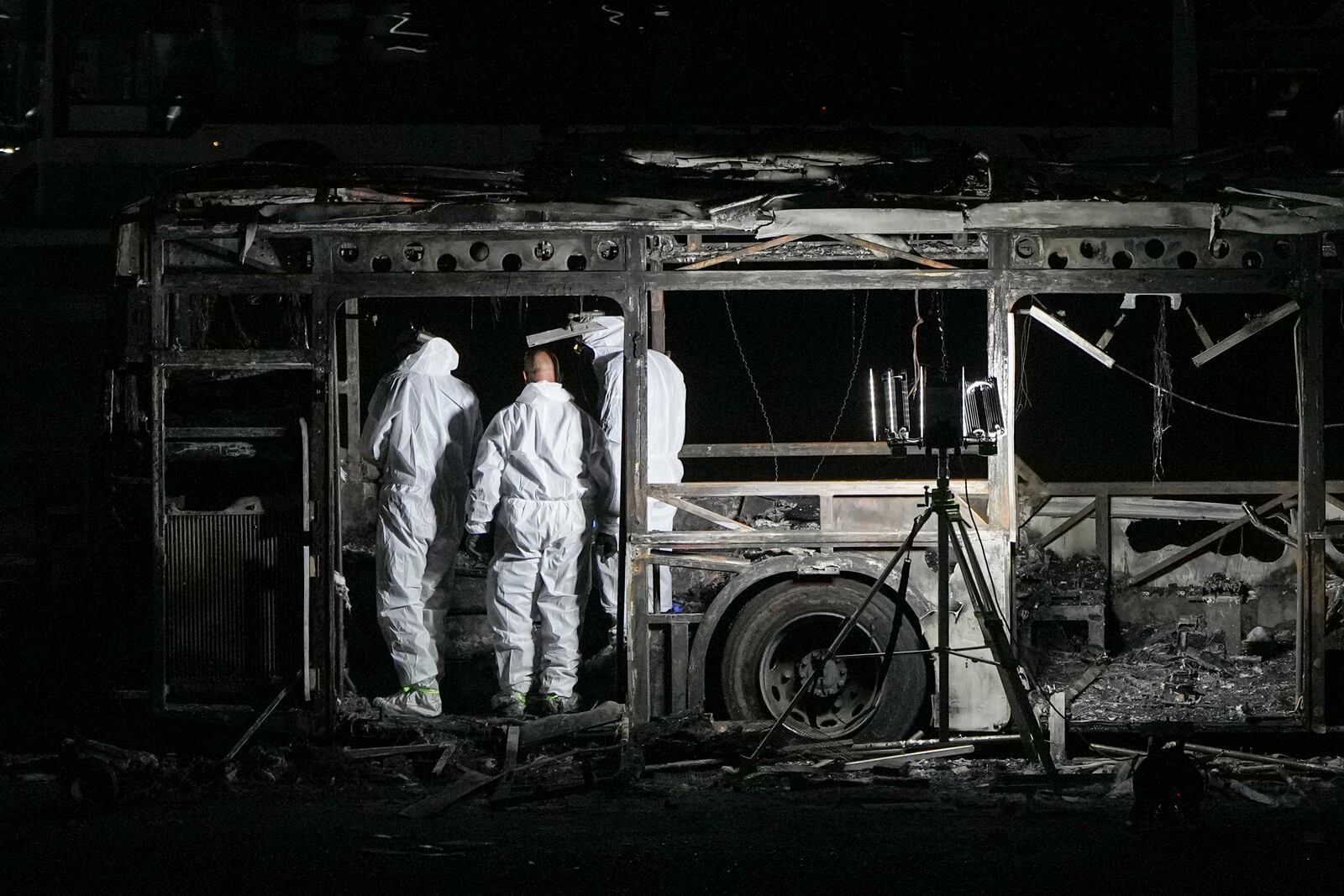 Israeli police inspect the scene of one of a series of bus explosions in what authorities said appeared to be a militant attack in Bat Yam, central Israel, Thursday, Feb. 20, 2025. (AP Photo/Ohad Zwigenberg)