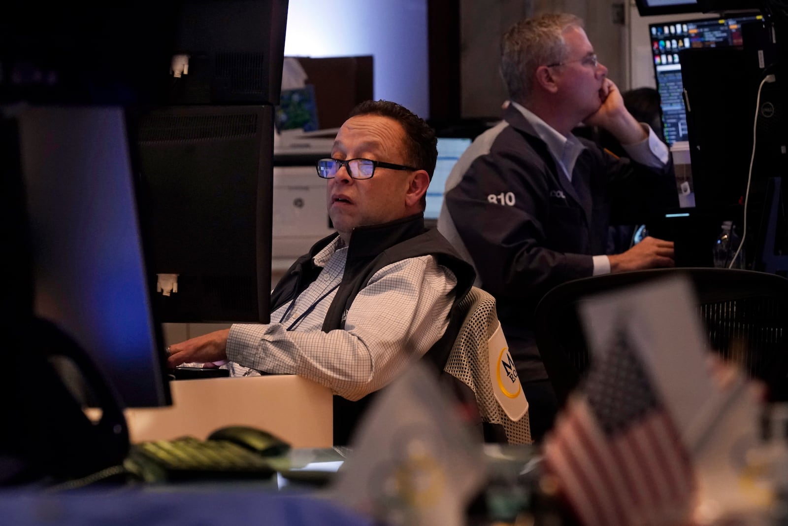 A pair of traders work on the floor of the New York Stock Exchange, Tuesday, March 11, 2025. (AP Photo/Richard Drew)