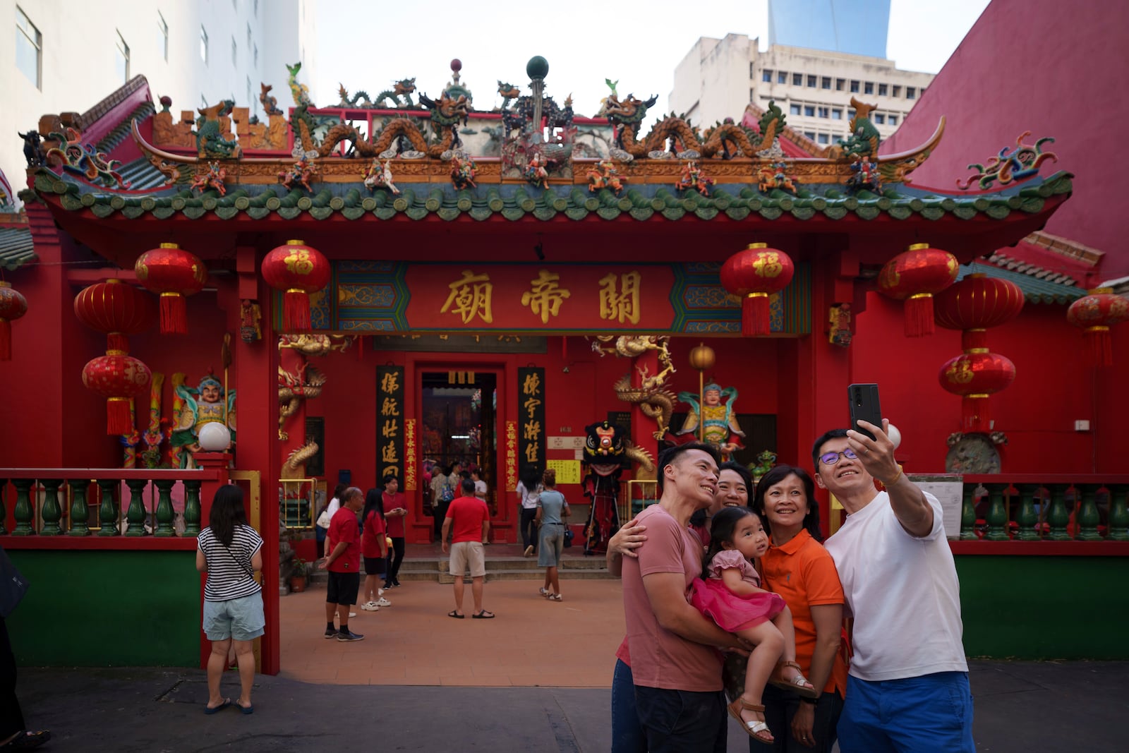 A Malaysian ethnic Chinese family takes picture on the first day of Lunar New Year at Guandi Temple, in Kuala Lumpur, Malaysia, Wednesday, Jan. 29, 2025. (AP Photo/Vincent Thian)