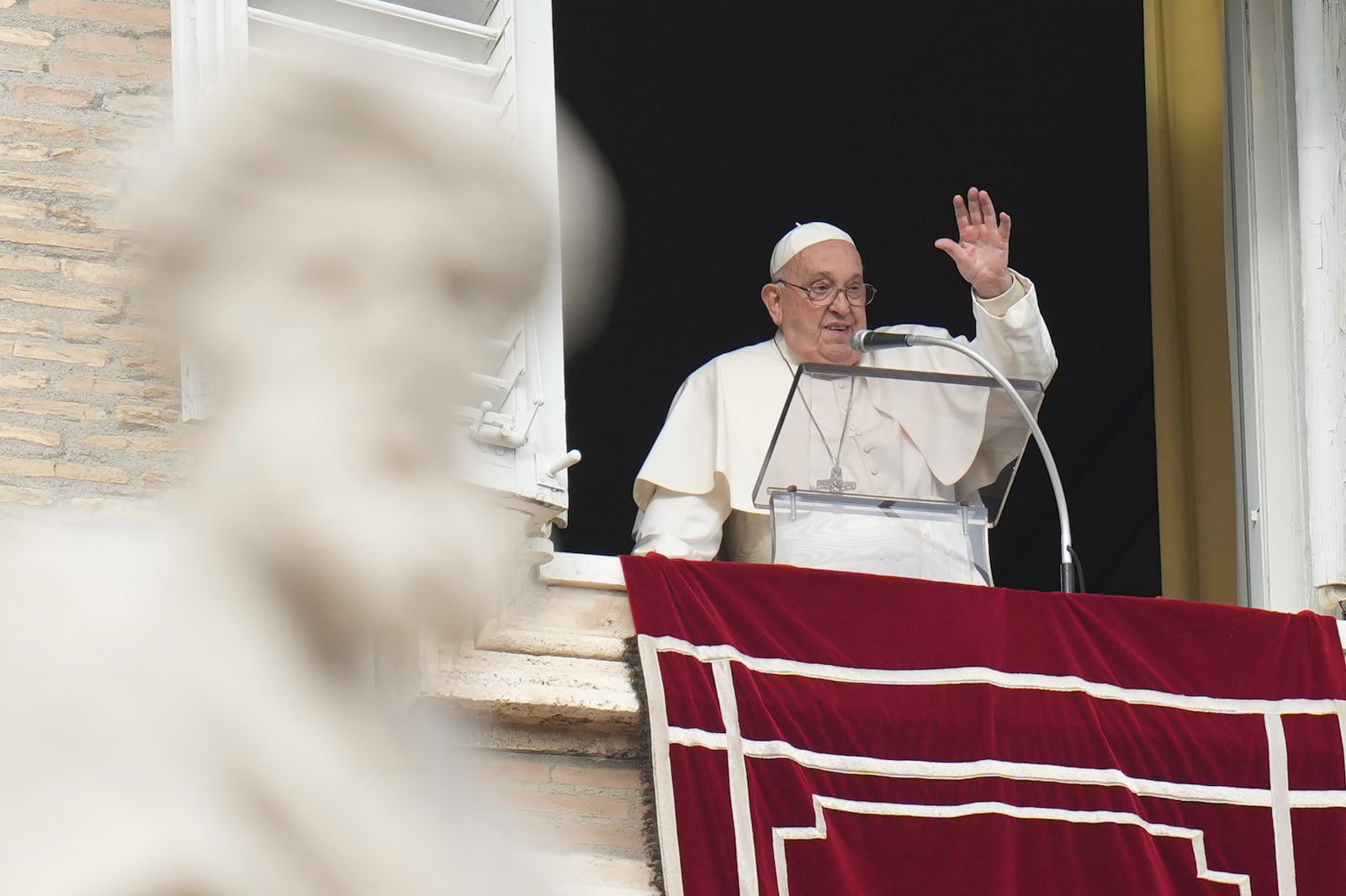 Pope Francis waves during the Angelus noon prayer on the occasion of the Epiphany day from the window of his studio overlooking St.Peter's Square, at the Vatican, Monday, Jan. 6, 2025. (AP Photo/Alessandra Tarantino)