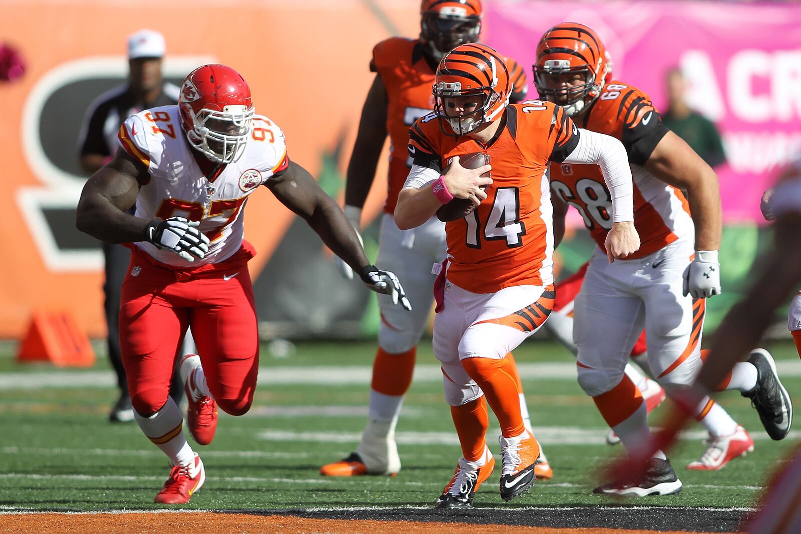 CINCINNATI, OH - OCTOBER 4:  Andy Dalton #14 of the Cincinnati Bengals scrambles for a first down as Allen Bailey #97 of the Kansas City Chiefs attempts to make a tackle during the fourth quarter at Paul Brown Stadium on October 4, 2015 in Cincinnati, Ohio. Cincinnati defeated Kansas City 36-21. (Photo by John Grieshop/Getty Images)