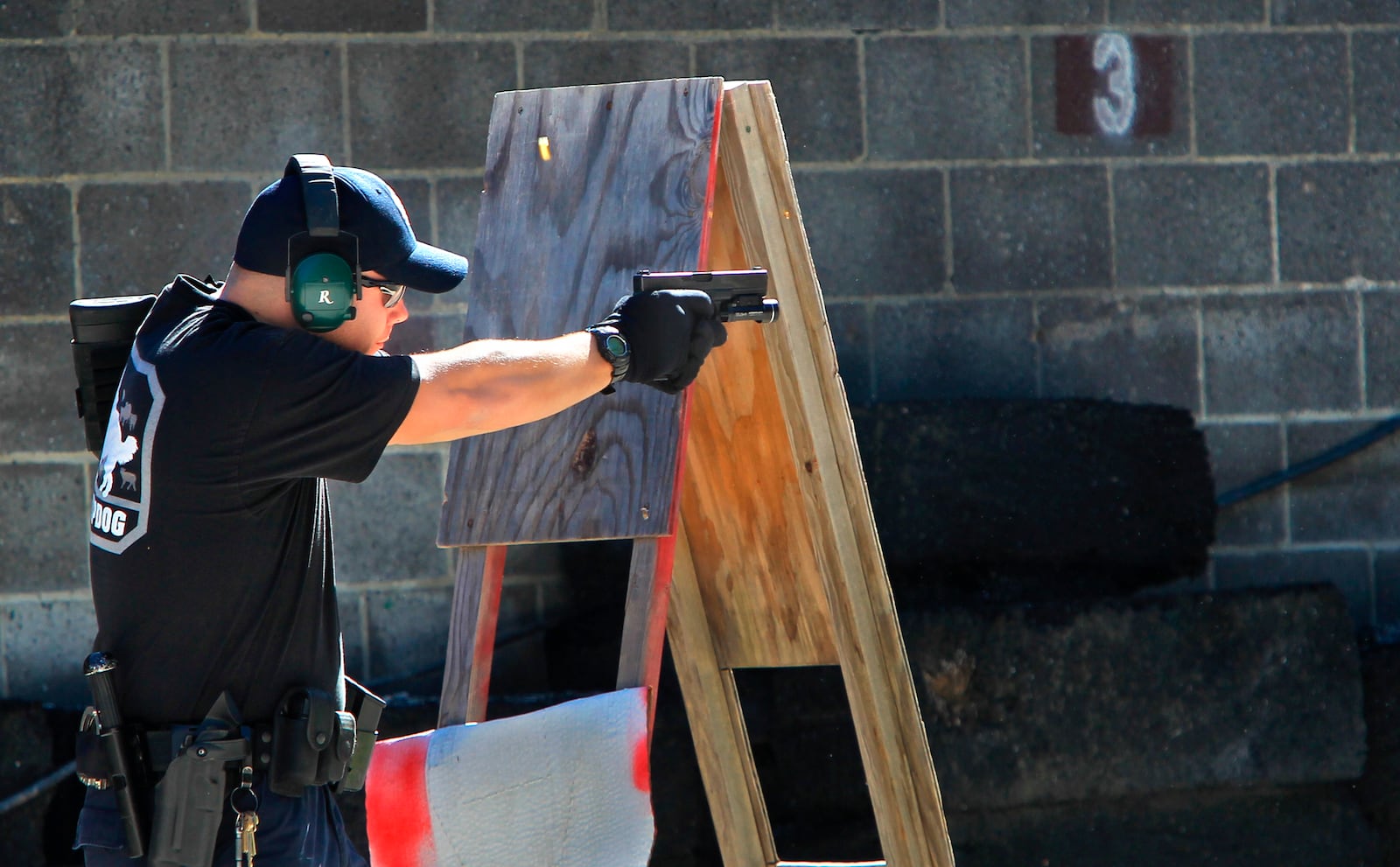 FILE—In this file photo from Oct. 8, 2013, police officer JR Lavish shoots a pistol during a police training exercise at the Eagle Creek Firearms Training Facility in Findlay, Ohio. After a 2016 shooting at Madison Local Schools in southwestern Ohio, a group of parents sued the district in September 2018 to prevent teachers from being armed without extensive training. The Ohio Supreme Court ruled Wednesday, June 23, 2021 that armed school employees must undergo an approved basic peace-officer-training program or have 20 years experience as a police officer. (Kelly Wilkinson/The Indianapolis Star via AP)