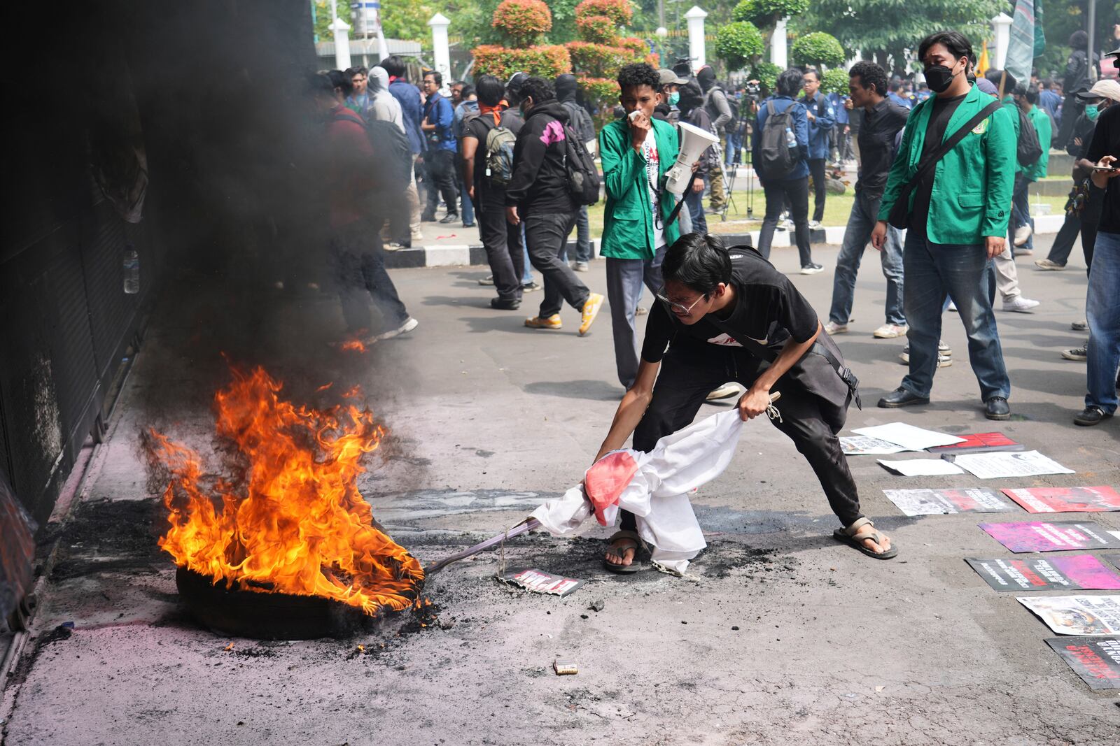 Student protesters burn a tire during a rally against the passing of a new military law allowing active military personnel to hold more civilian posts, outside the parliament in Jakarta, Indonesia, Thursday, March 20, 2025. (AP Photo/Tatan Syuflana)