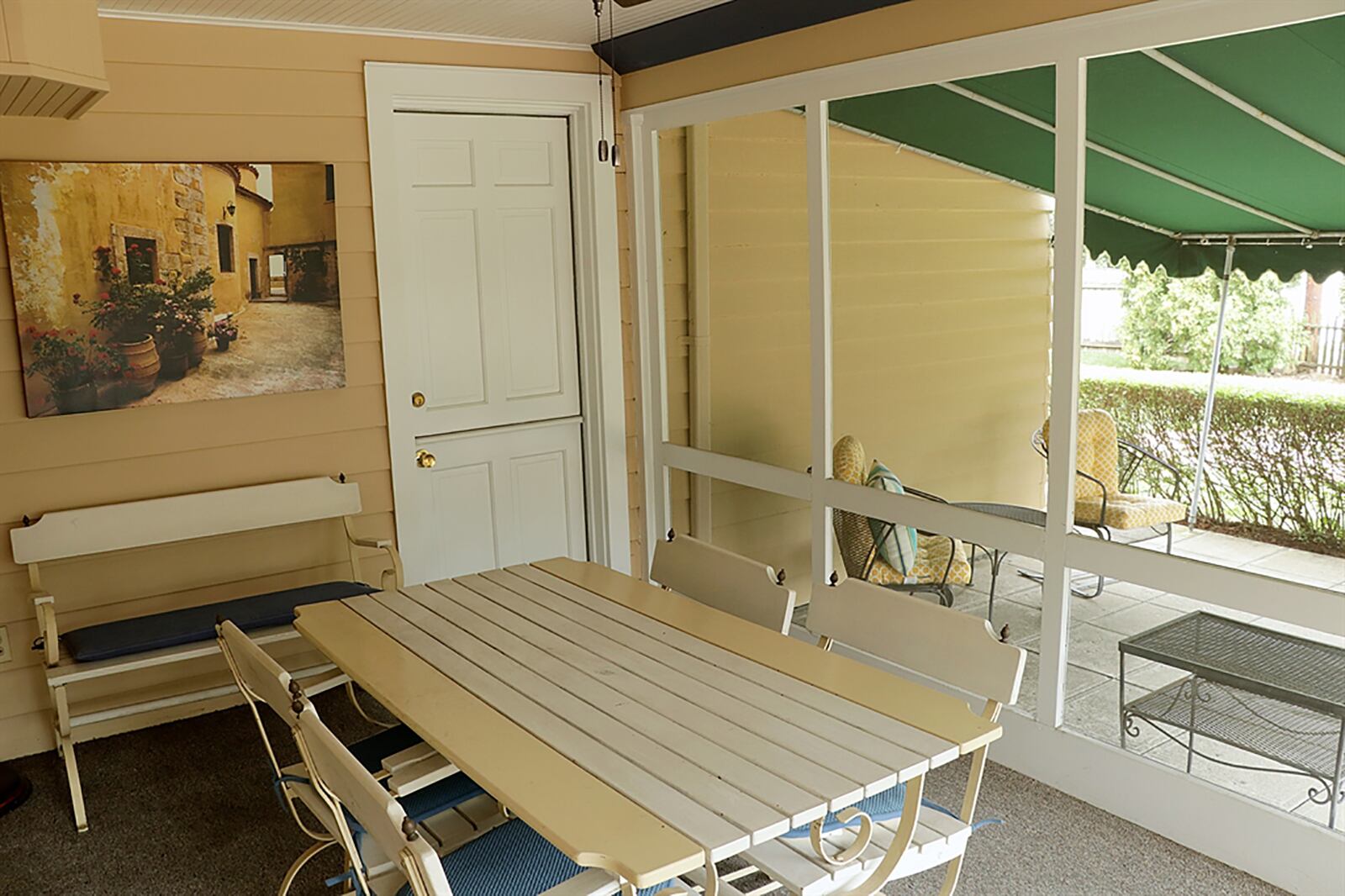 A Dutch door opens from the keeping room to a screen-enclosed porch with a tongue-and-groove ceiling, a ceiling paddle fan and outdoor carpeting. The screened porch opens to a covered concrete stone patio that feeds into a brick sun patio and the back yard. CONTRIBUTED PHOTO BY KATHY TYLER