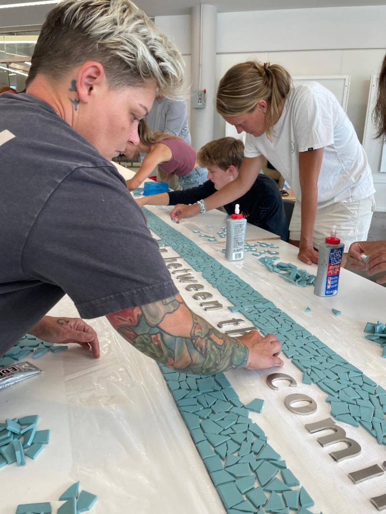 Jes McMillan of the Mosaic Institute, a member of the "Seed of Life" design team, adds tiles to the 8/4 Memorial mosaic. PHOTO BY RUSSELL FLORENCE JR.