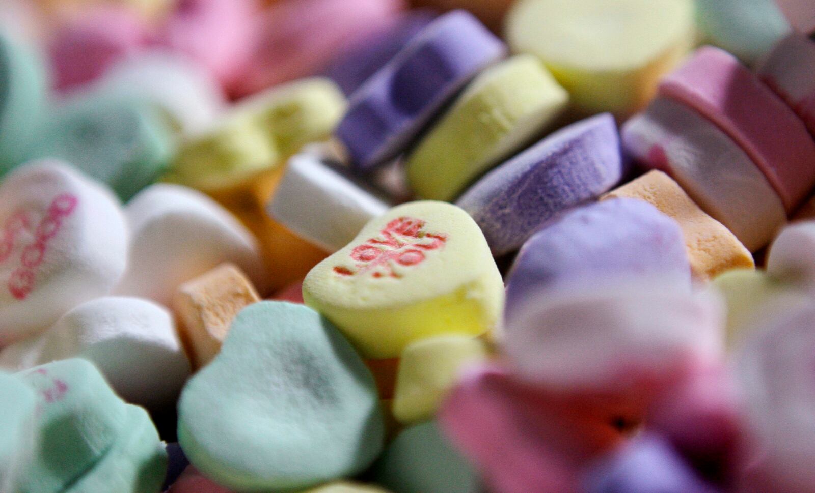 FILE - Assorted "Sweethearts" candy is held in bulk prior to packaging at the New England Confectionery Company in Revere, Mass., on Jan. 14, 2009. (AP Photo/Charles Krupa, File)