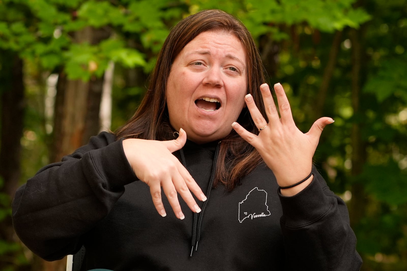 Megan Vozzella uses sign language during an interview about her late husband, Stephen Vozzella, who was one of the people killed in a mass shooting on Oct. 25, 2023, in Lewiston, Tuesday, Oct. 1, 2024, in Oxford, Maine. (AP Photo/Robert F. Bukaty)