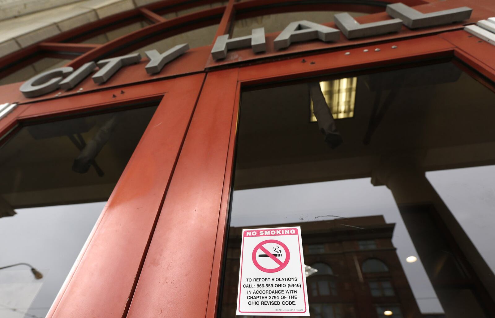 A no smoking sign is on the doors of Dayton City Hall to comply with Ohio Revised Code for public buildings. The city has added nicotine testing for new hires as its own policy. TY GREENLEES / STAFF