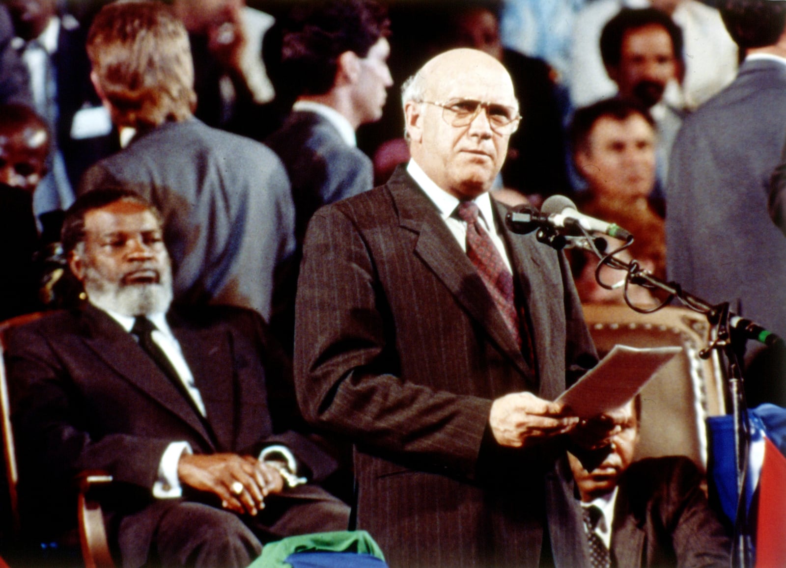 FILE - South African President F.W. de Klerk delivers his speech in Windhoek, Namibia, March 21, 1990, where he handed over Namibia to Namibian President Sam Nujoma, seated left, during an independence ceremony. (AP Photo/John Parkin, File)