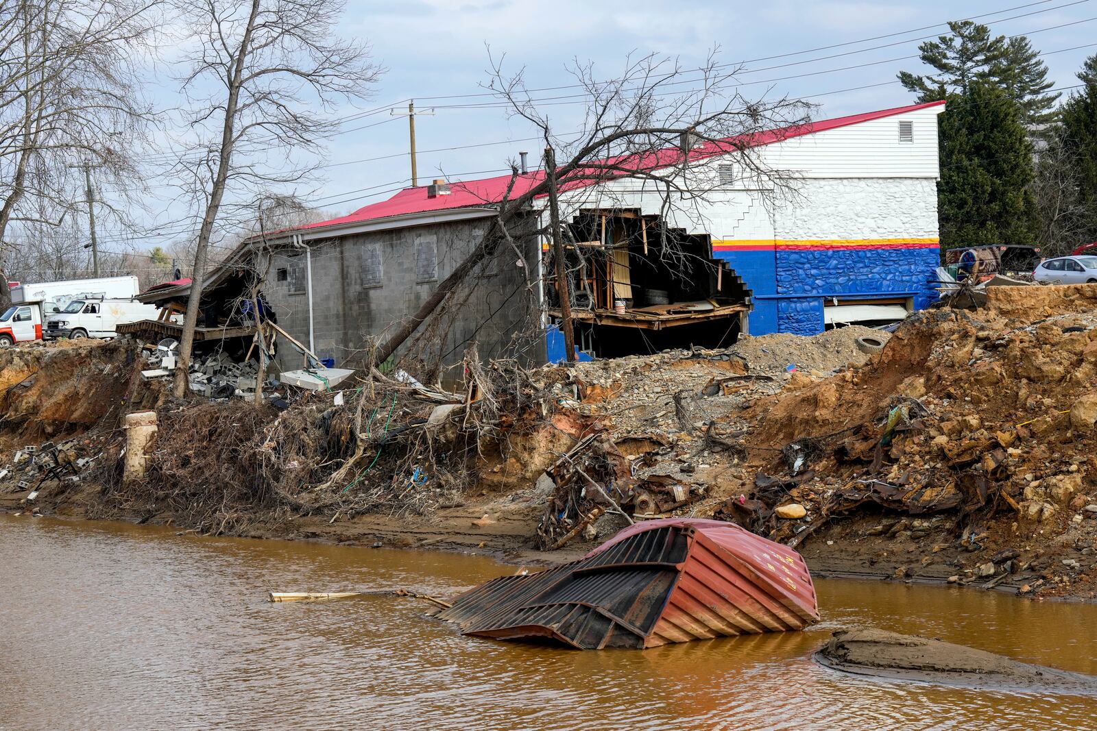 A view of the Swannanoa River and several buildings destroyed by Hurricane Helene as seen from the edge of Vickie Revis' property, Wednesday, Feb. 5, 2025, in Swannanoa, N.C. (AP Photo/Kathy Kmonicek)