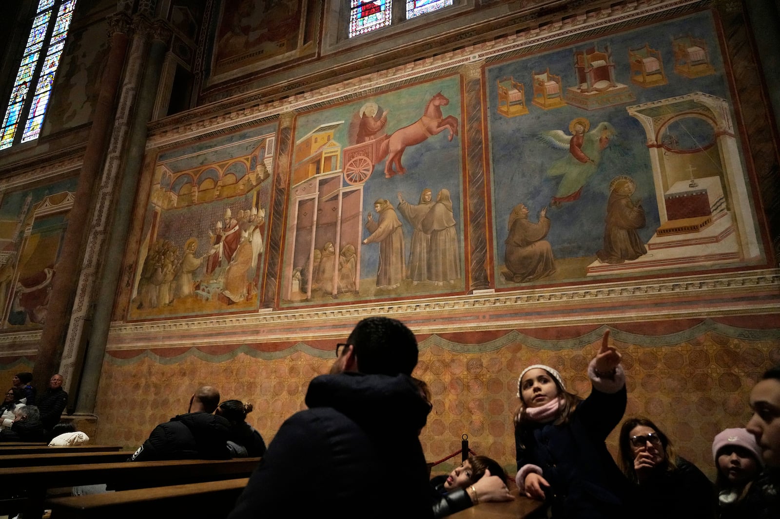 People admire Giotto's frescoes inside St. Francis Basilica in Assisi, Italy, Saturday, March 1, 2025. (AP Photo/Gregorio Borgia)