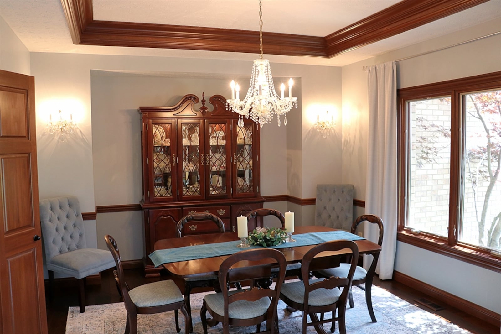 The formal dining room has a tray ceiling with a crystal chandelier. 