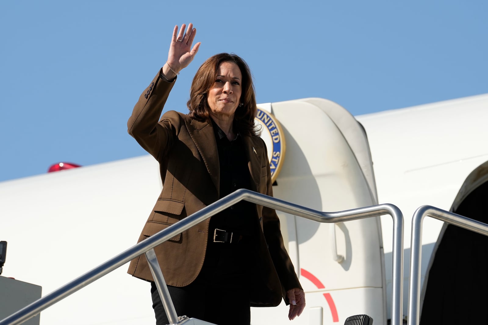 Democratic presidential nominee Vice President Kamala Harris waves as she boards Air Force Two, Friday, Oct. 11, 2024, at Sky Harbor International Airport in Phoenix, en route to Washington. (AP Photo/Ross D. Franklin)