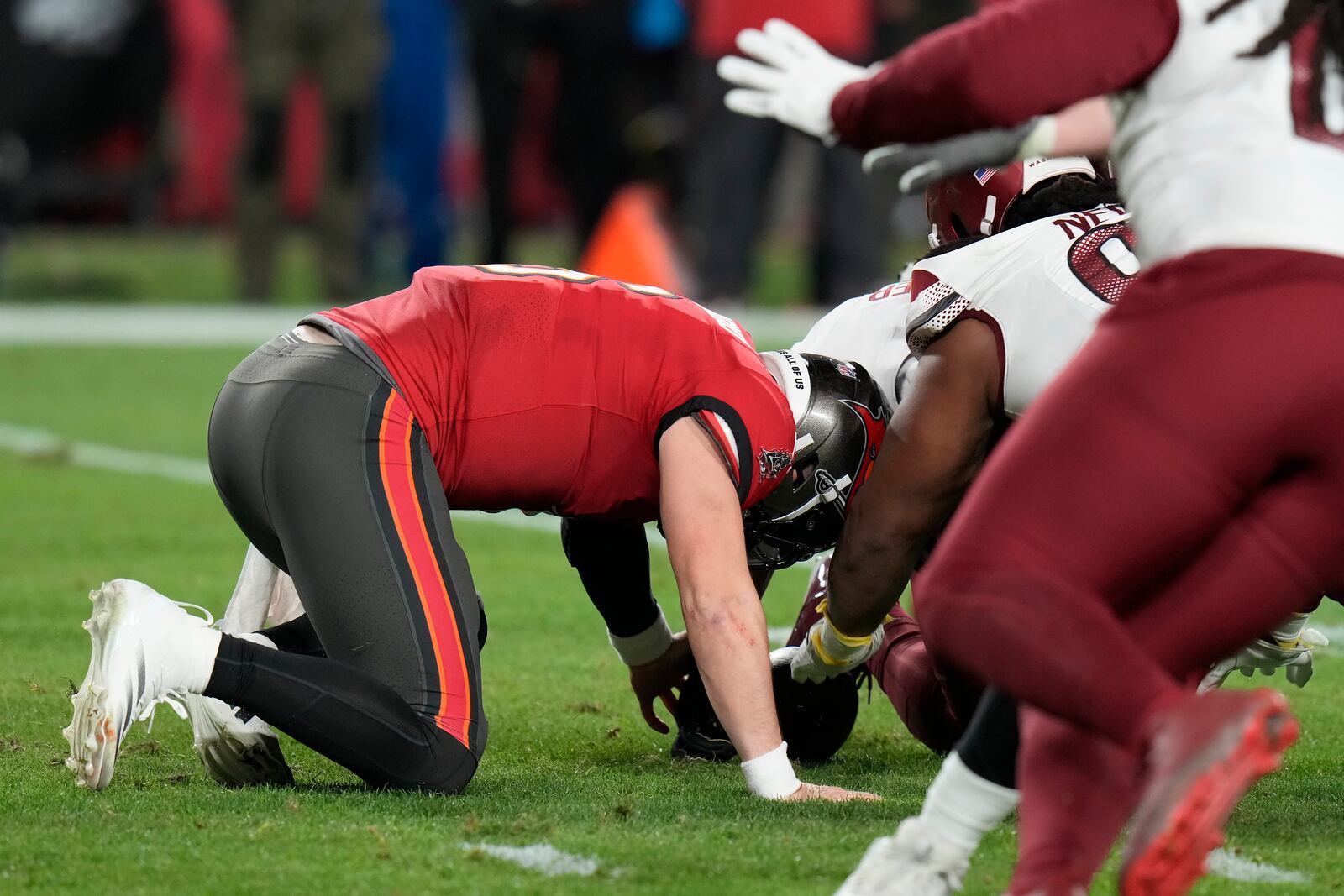 Tampa Bay Buccaneers quarterback Baker Mayfield, left, fumbles the ball, which was recovered by Washington Commanders linebacker Bobby Wagner, during the second half of an NFL wild-card playoff football game in Tampa, Fla., Sunday, Jan. 12, 2025. (AP Photo/Chris O'Meara)