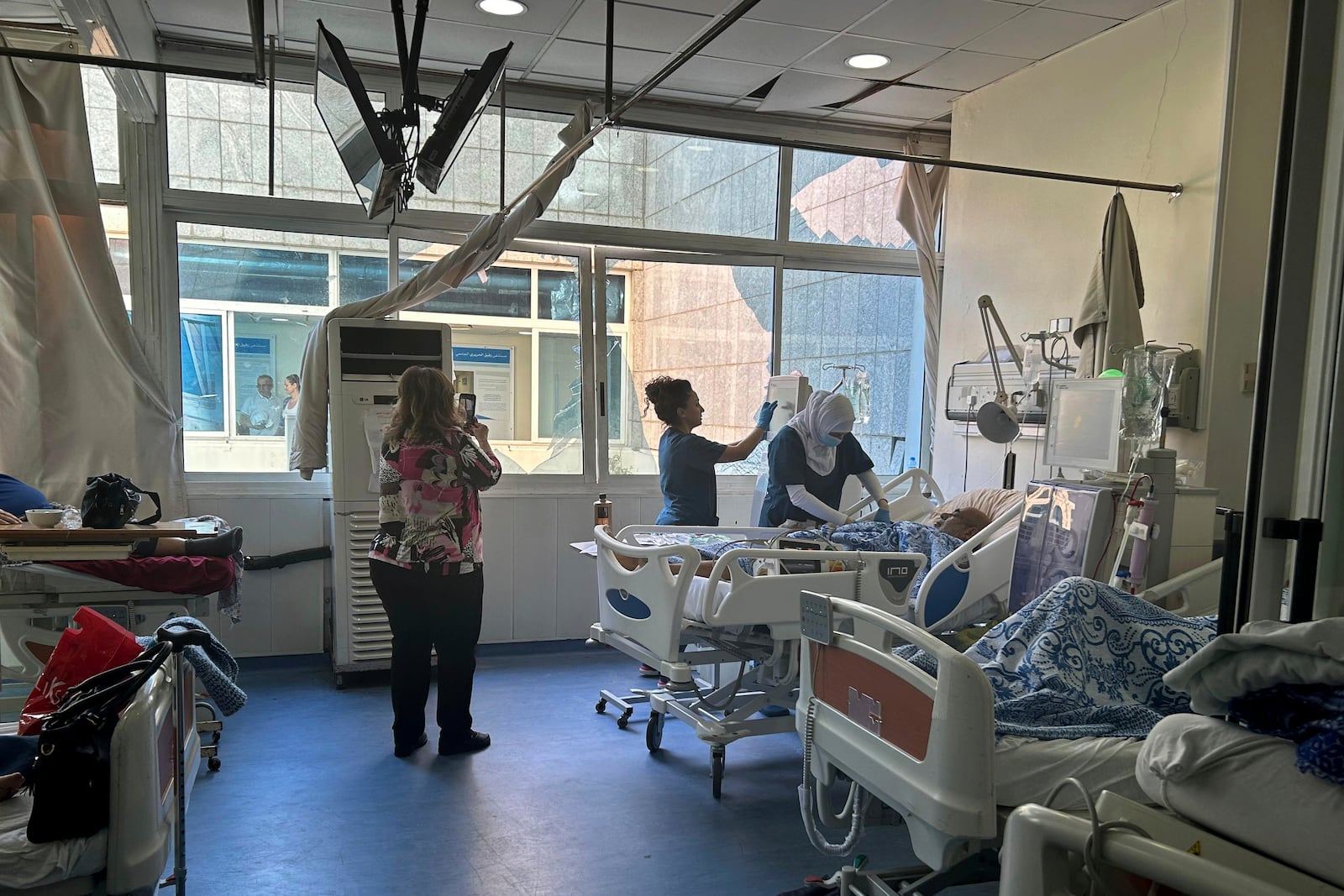 Patients receive treatment at the dialysis unit near broken window at the Rafik Hariri University Hospital, following an overnight Israeli airstrike near the medical facility in southern Beirut, Lebanon, Tuesday, Oct. 22, 2024. (AP Photo/Sarah el-Deeb)