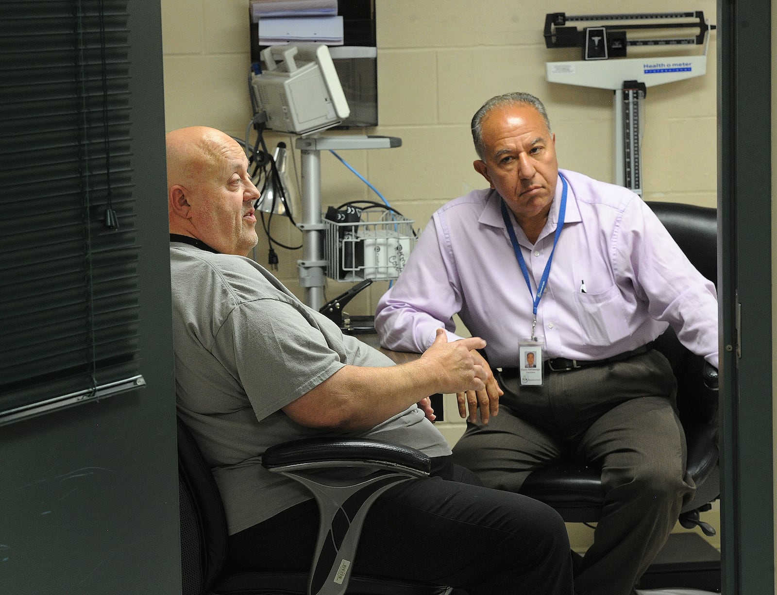 Therapist Larry Stephens (left) and Psychiatrist Esam Alkhawaga (right) discuss patient care at Dr. A's office at the Greene County Jail. MARSHALL GORBY/STAFF