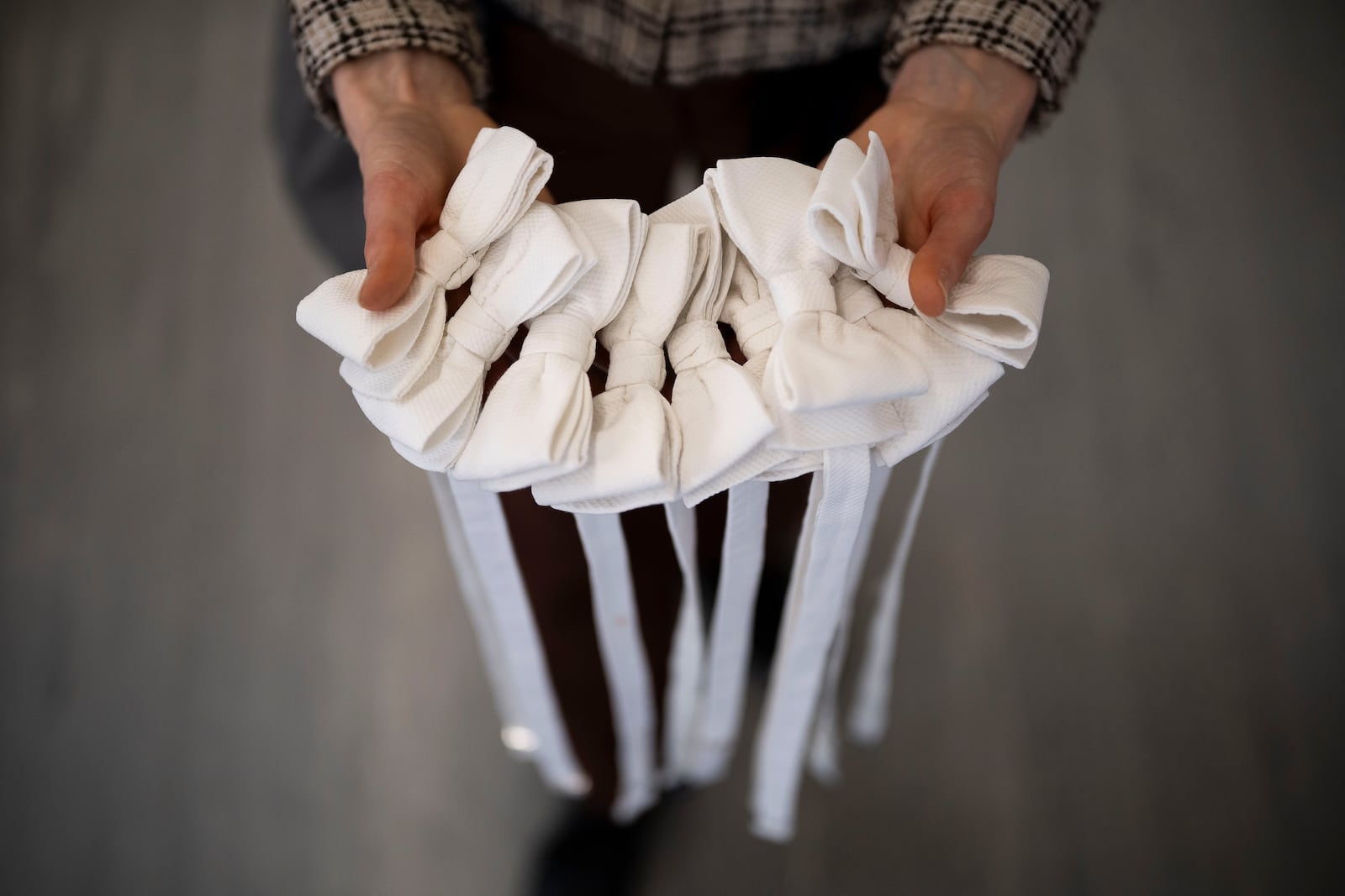 An employee holds bow ties in Lambert Hofer, a renowned costume workshop in Vienna, Austria, Wednesday, Febr 26, 2025. (AP Photo/Denes Erdos)