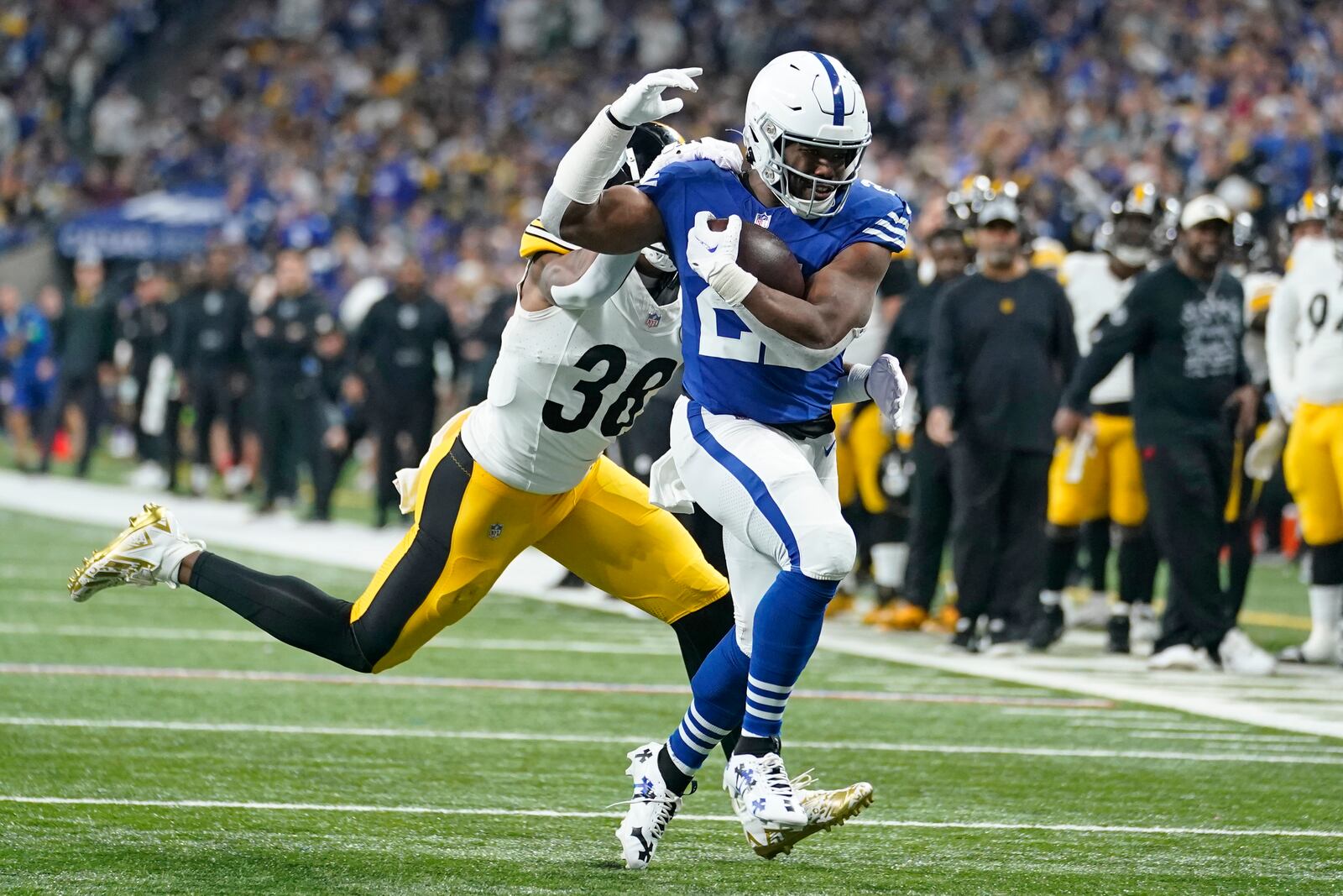 Indianapolis Colts running back Zack Moss,right, gets past Pittsburgh Steelers linebacker Mykal Walker (38) to score during the first half of an NFL football game in Indianapolis Saturday, Dec. 16, 2023. (AP Photo/Michael Conroy)