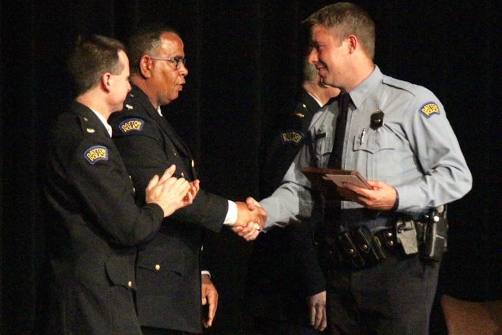 Dayton police officer Jason Olson, right, recipient of the Steve Whalen Memorial Policing Award, shakes hands with Lt. Col. Mark Ecton. CHUCK HAMLIN / STAFF