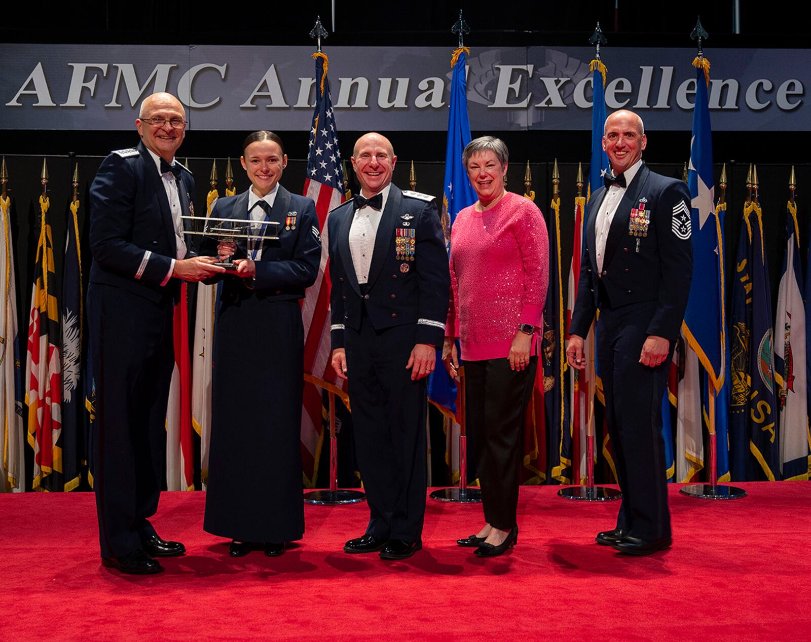 Gen. Arnold Bunch Jr. (far left), Air Force Materiel Command commander, presents the AFMC Airman of the Year Award to Senior Airman Kayla Stevens, Air Force Life Cycle Management Center, during the command’s Annual Excellence Awards Banquet on March 23 in the National Museum of the U.S. Air Force. U.S. AIR FORCE PHOTO/R.J. ORIEZ