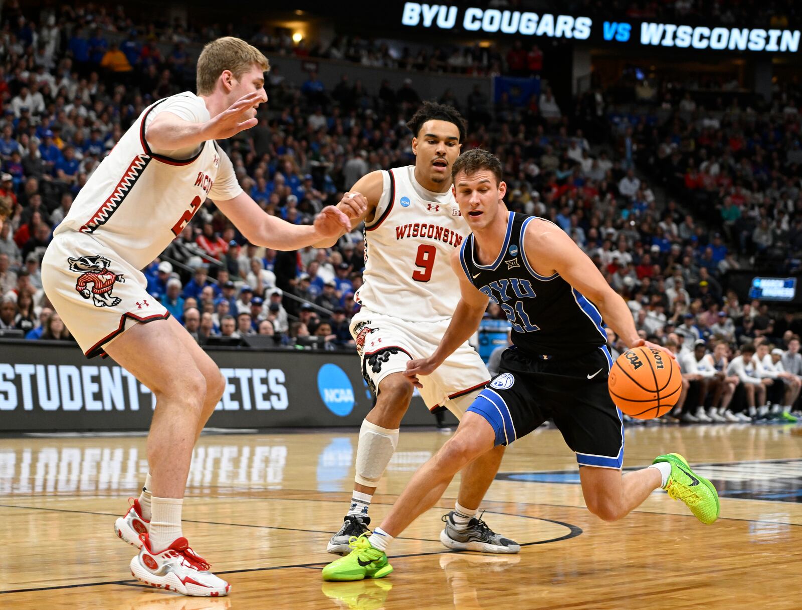 Brigham Young guard Trevin Knell, front right, collects a loose ball as Wisconsin forward Steven Crowl, left, and guard John Tonje defend during the first half in the second round of the NCAA college basketball tournament Saturday, March 22, 2025, in Denver. (AP Photo/John Leyba)