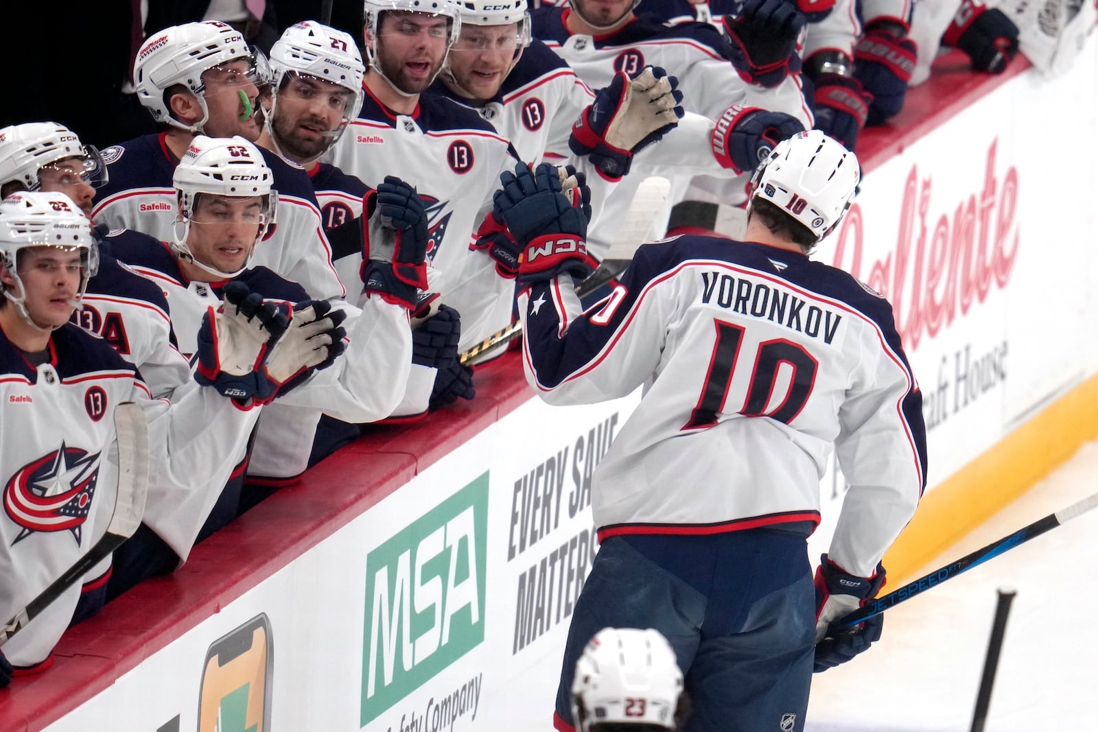 Columbus Blue Jackets' Dmitri Voronkov (10) returns to the bench after scoring during the first period of an NHL hockey game against the Pittsburgh Penguins in Pittsburgh, Tuesday, Jan. 7, 2025. (AP Photo/Gene J. Puskar)