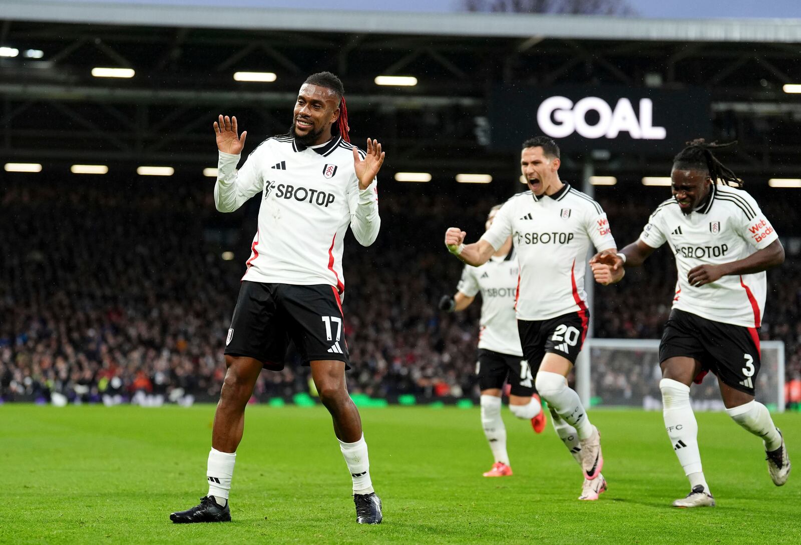 Fulham's Alex Iwobi, left, celebrates after scoring the opening goal during the English Premier League match between Fulham and Wolverhampton Wanderers at Craven Cottage stadium in London, Saturday, Nov. 23, 2024. (Zac Goodwin/PA via AP)